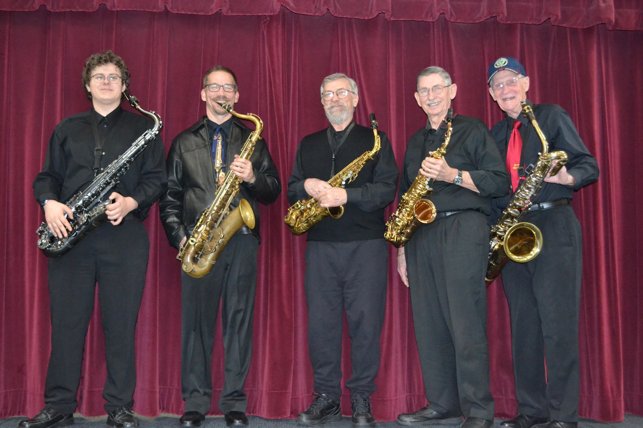 The SwingMasters saxophone section posing together on stage