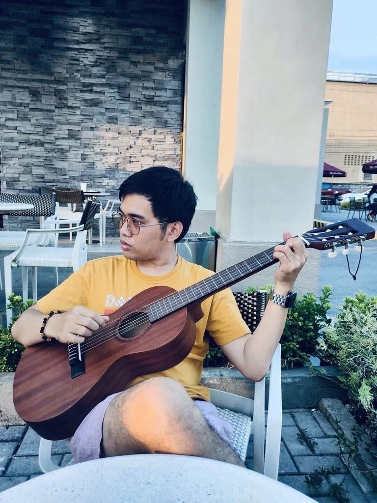 Richard, Timberyard Full Stack Developer, sitting playing his guitar