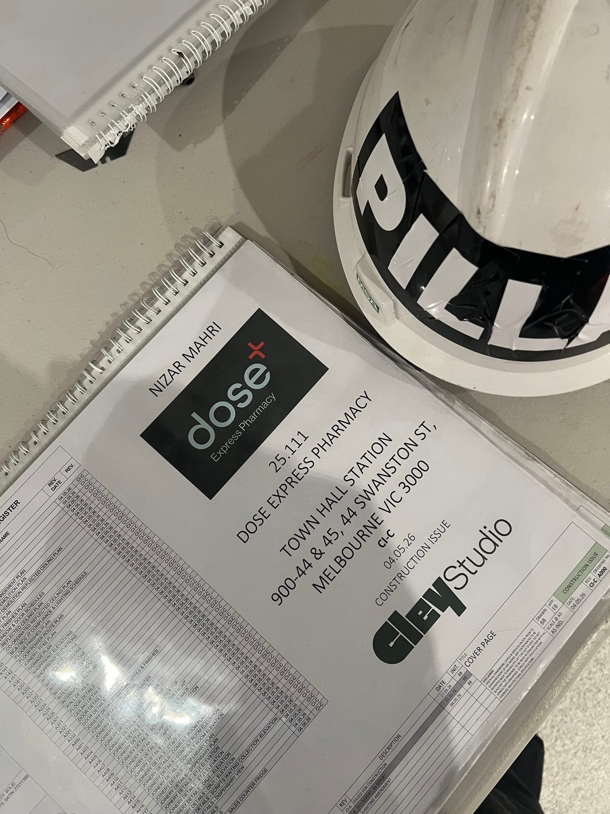 Construction-issue drawings and Pillar hard hat on the Dose Pharmacy site