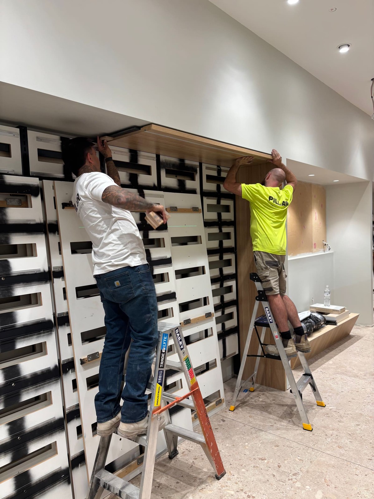 Pillar team installing feature joinery on site