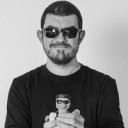 Desarrollador de software con gafas de sol y sosteniendo un patito de goma de juguete.