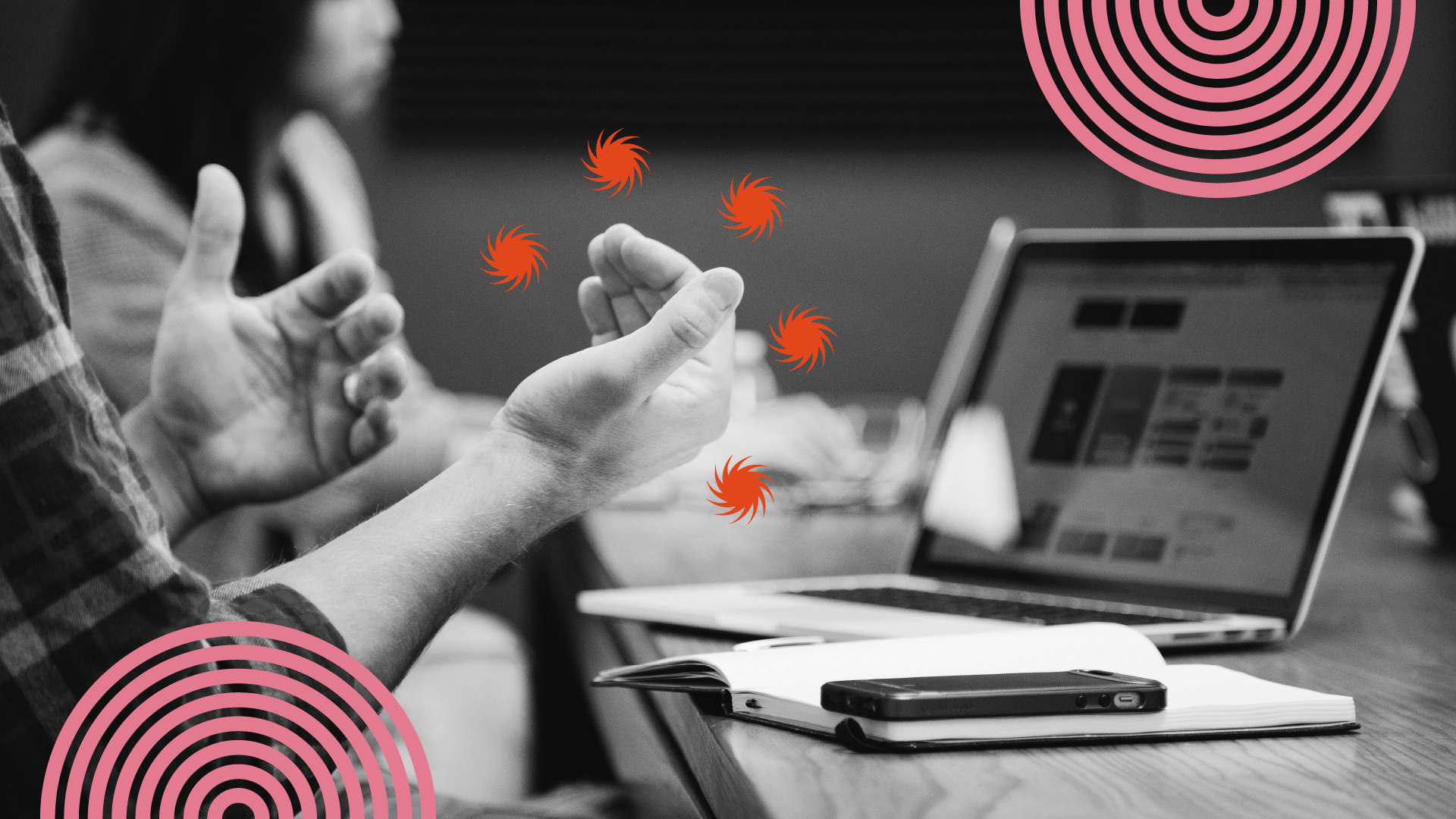 Desarrollador frente a su computadora moviendo sus manos como si estuviera explicando algo.