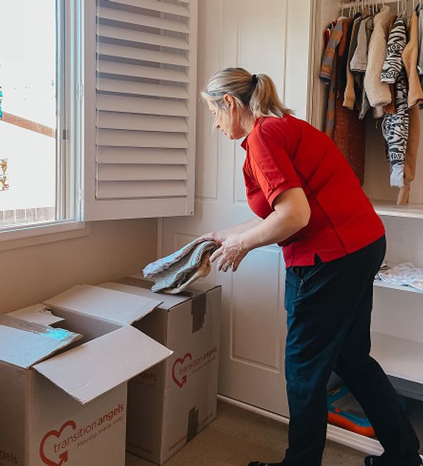 Transition Angels team member packing items into a large box