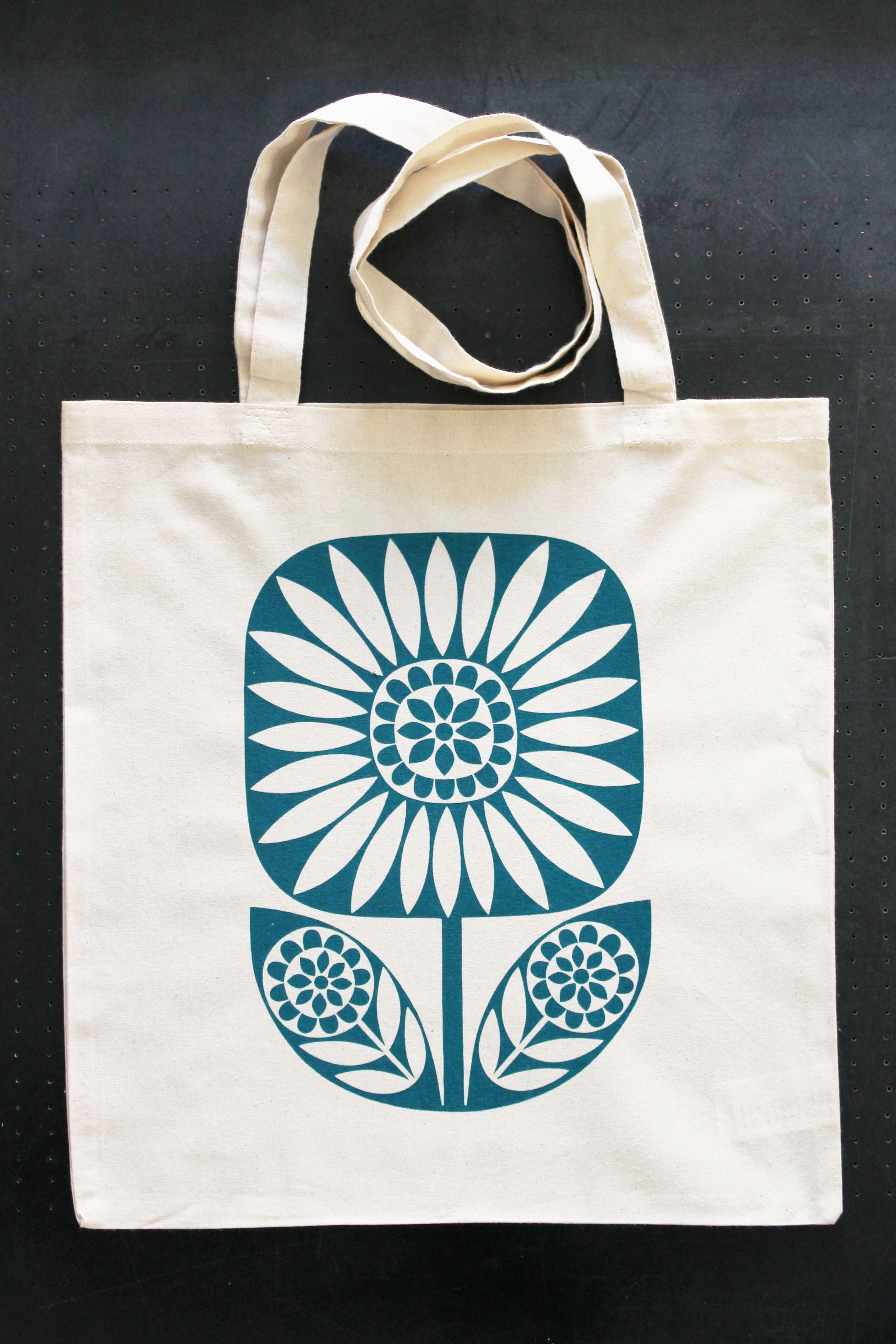 screenprinted tote bag; graphic flower in teal