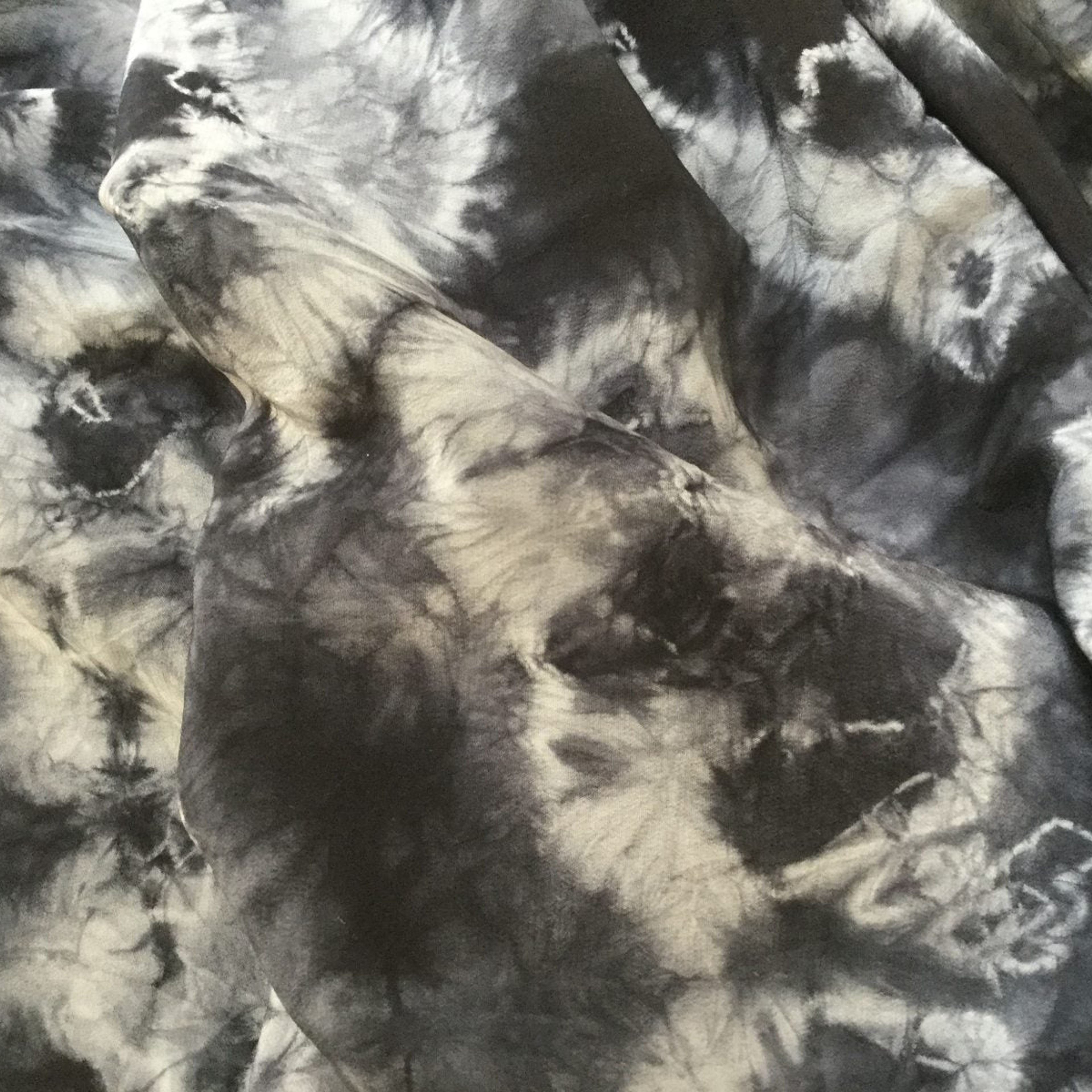shibori dyed textile. black background white pattern