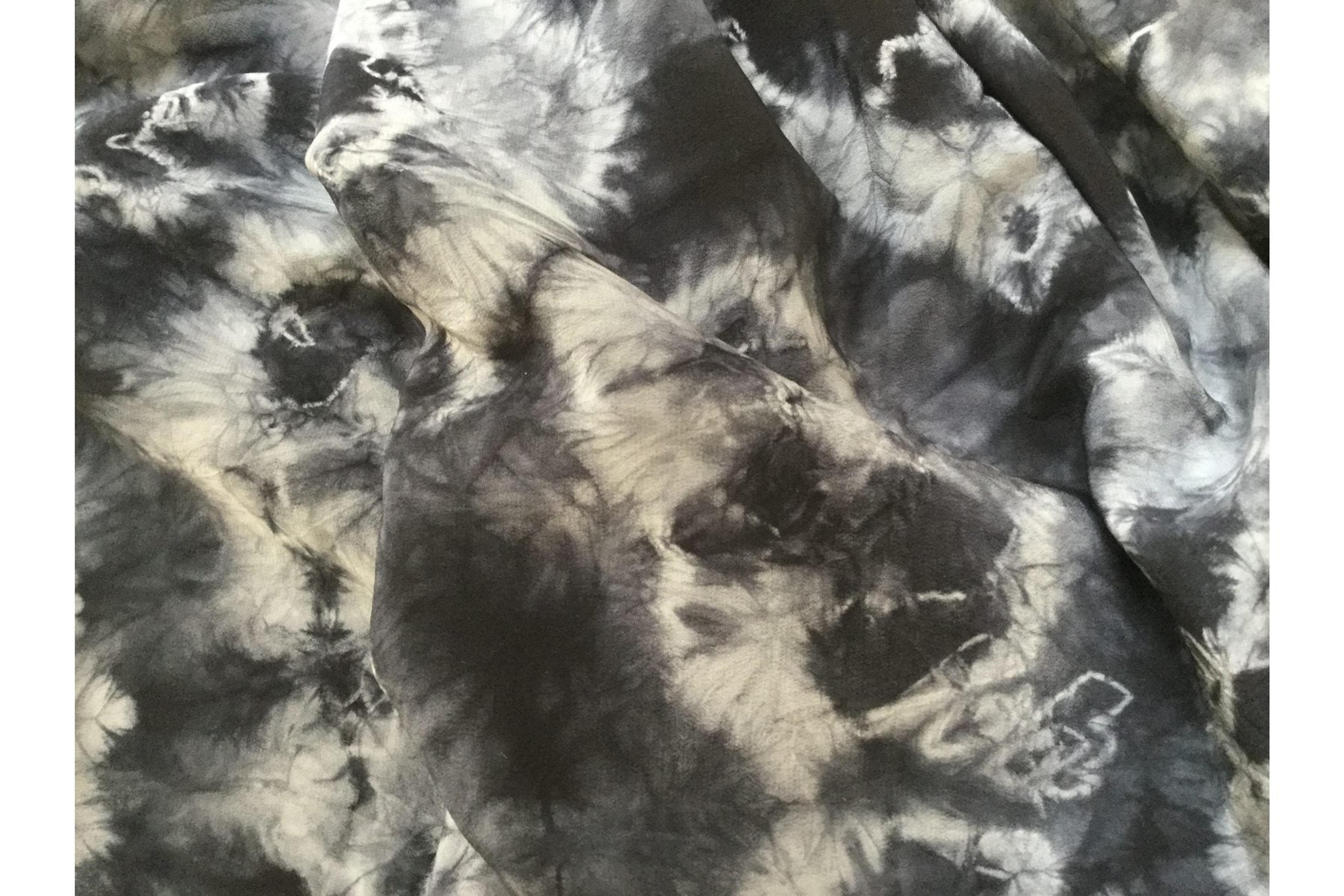 shibori dyed textile. black background white pattern