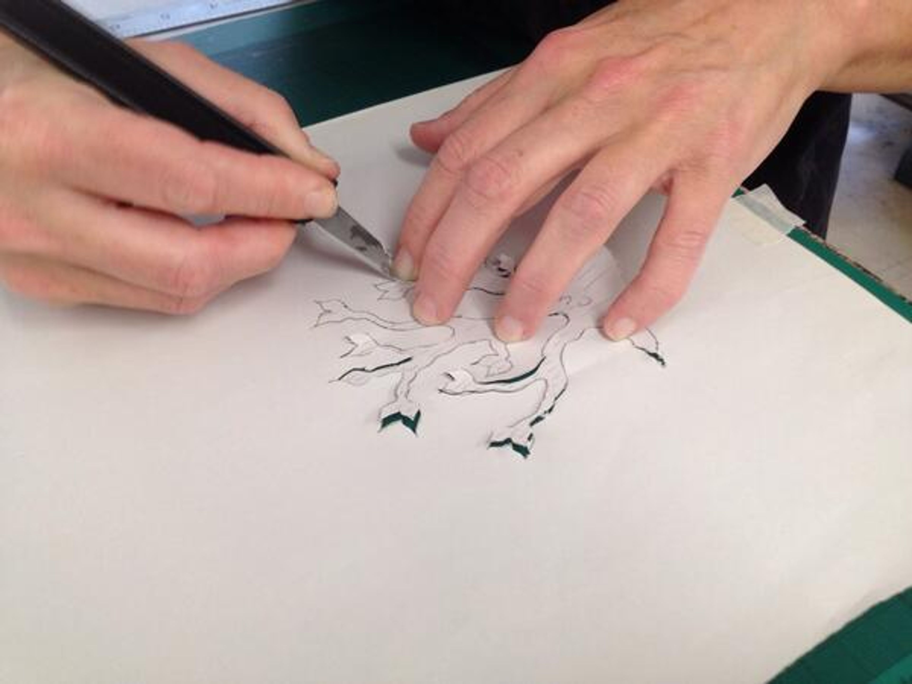 photo of hands cutting out stencil with knife