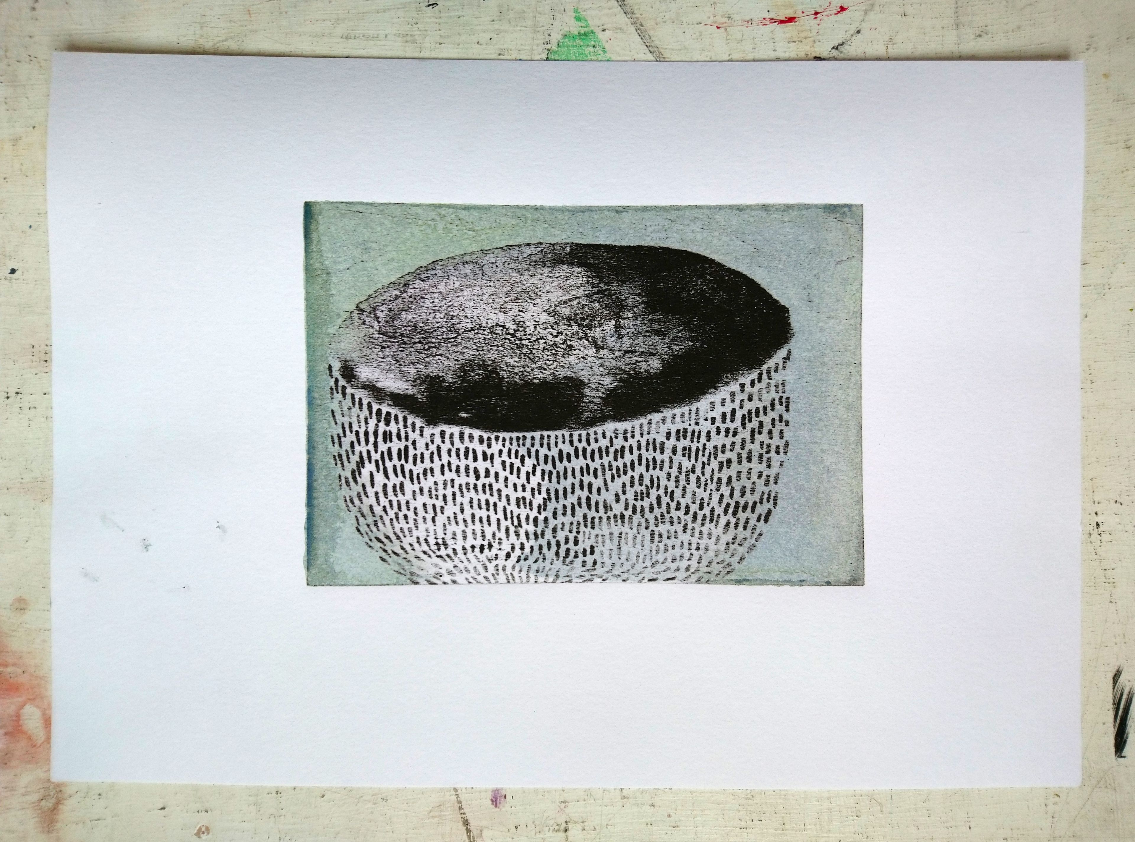 lithography print; black and white textured archaeological bowl against muted green background