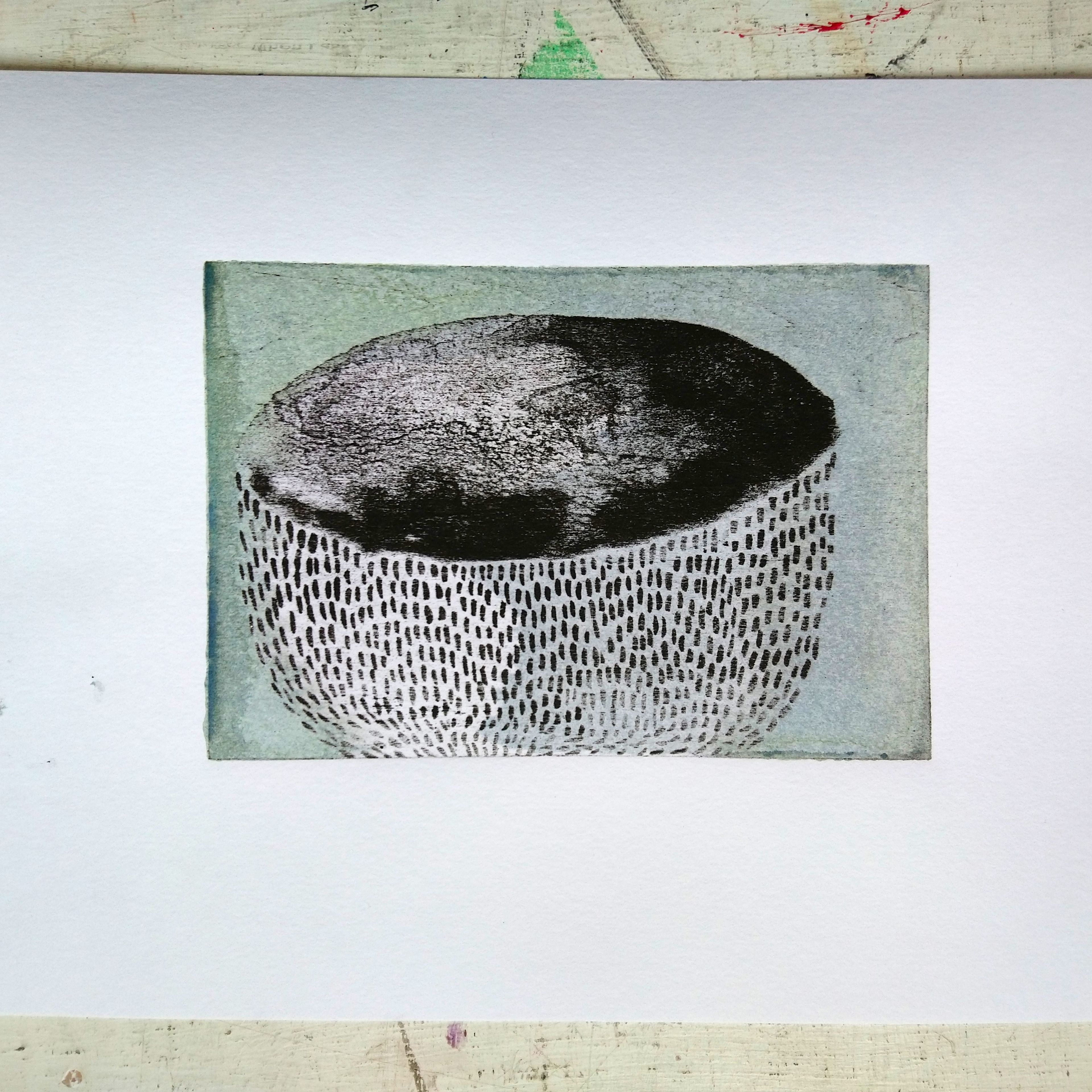 lithography print; black and white textured archaeological bowl against muted green background