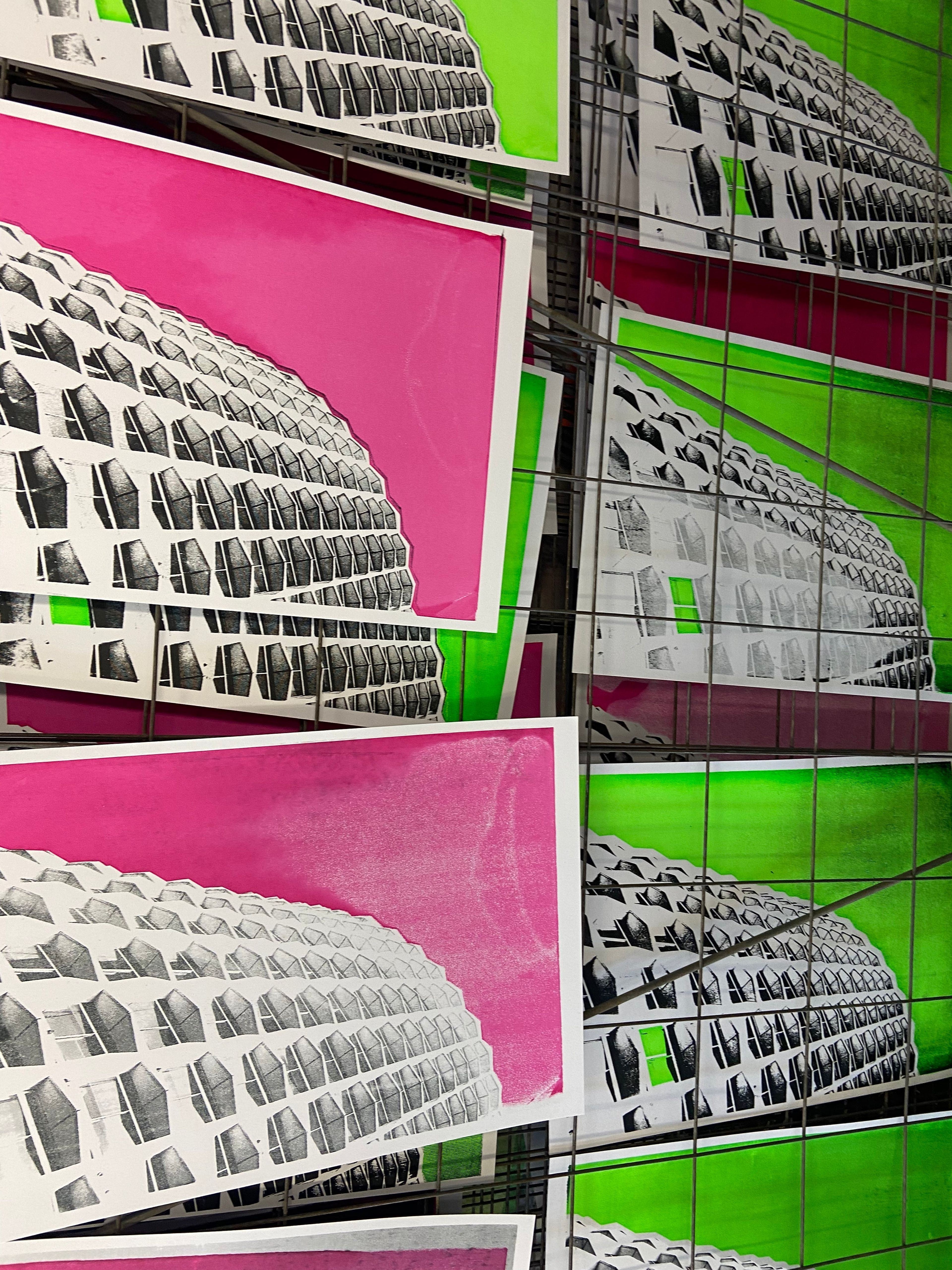 neon pink and green background screenprints on drying rack