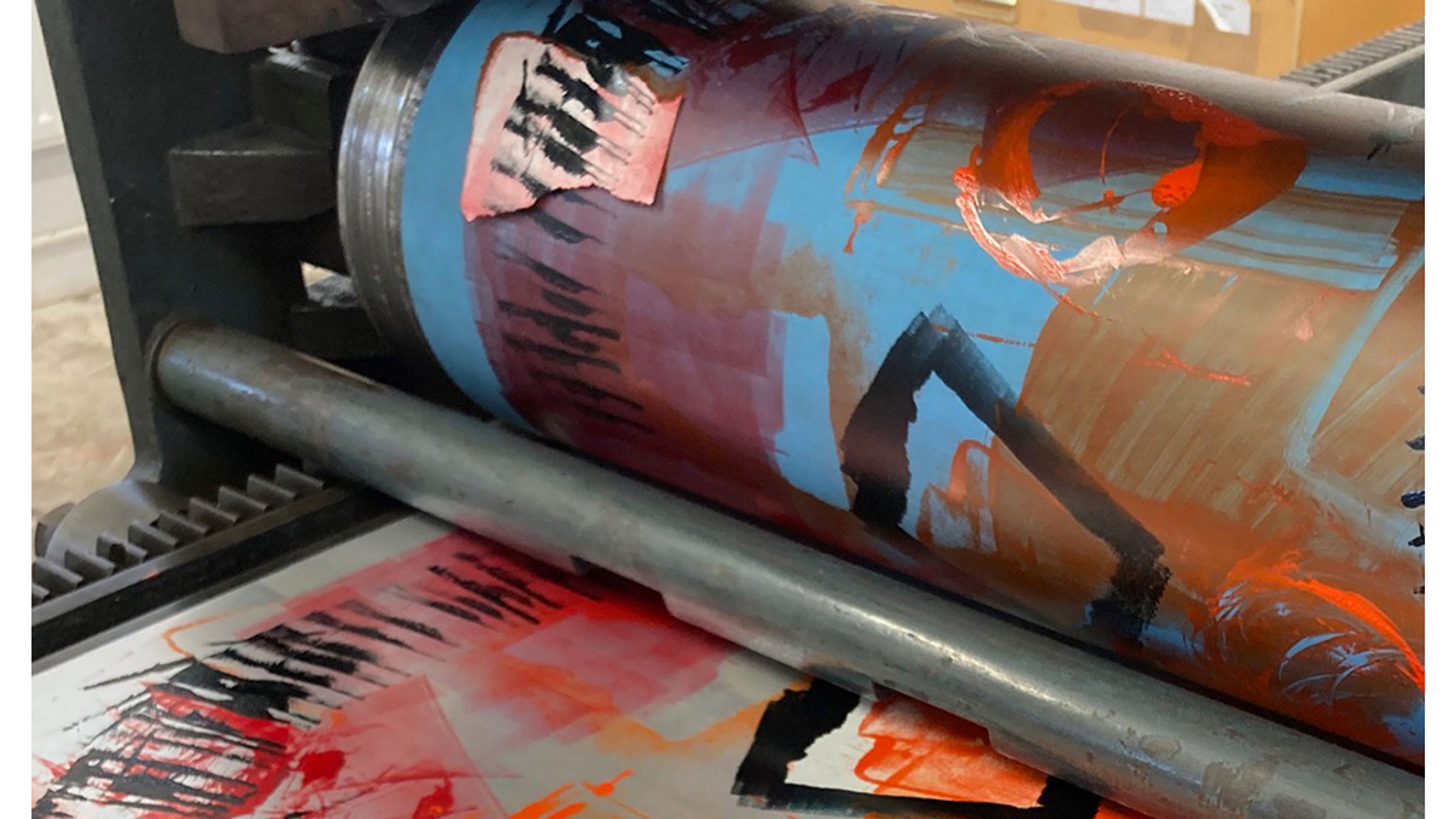 close up photo of multicoloured ink being rolled through offset lithography press