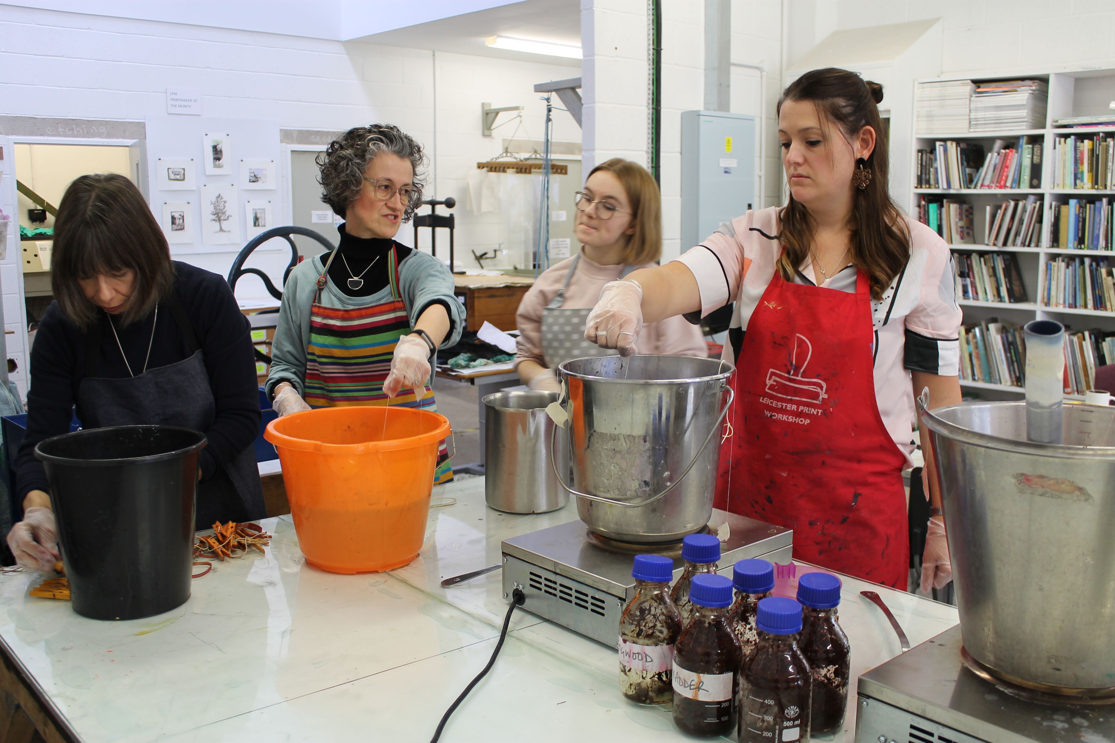 photo of 4 women dying textiles in buckets and pans