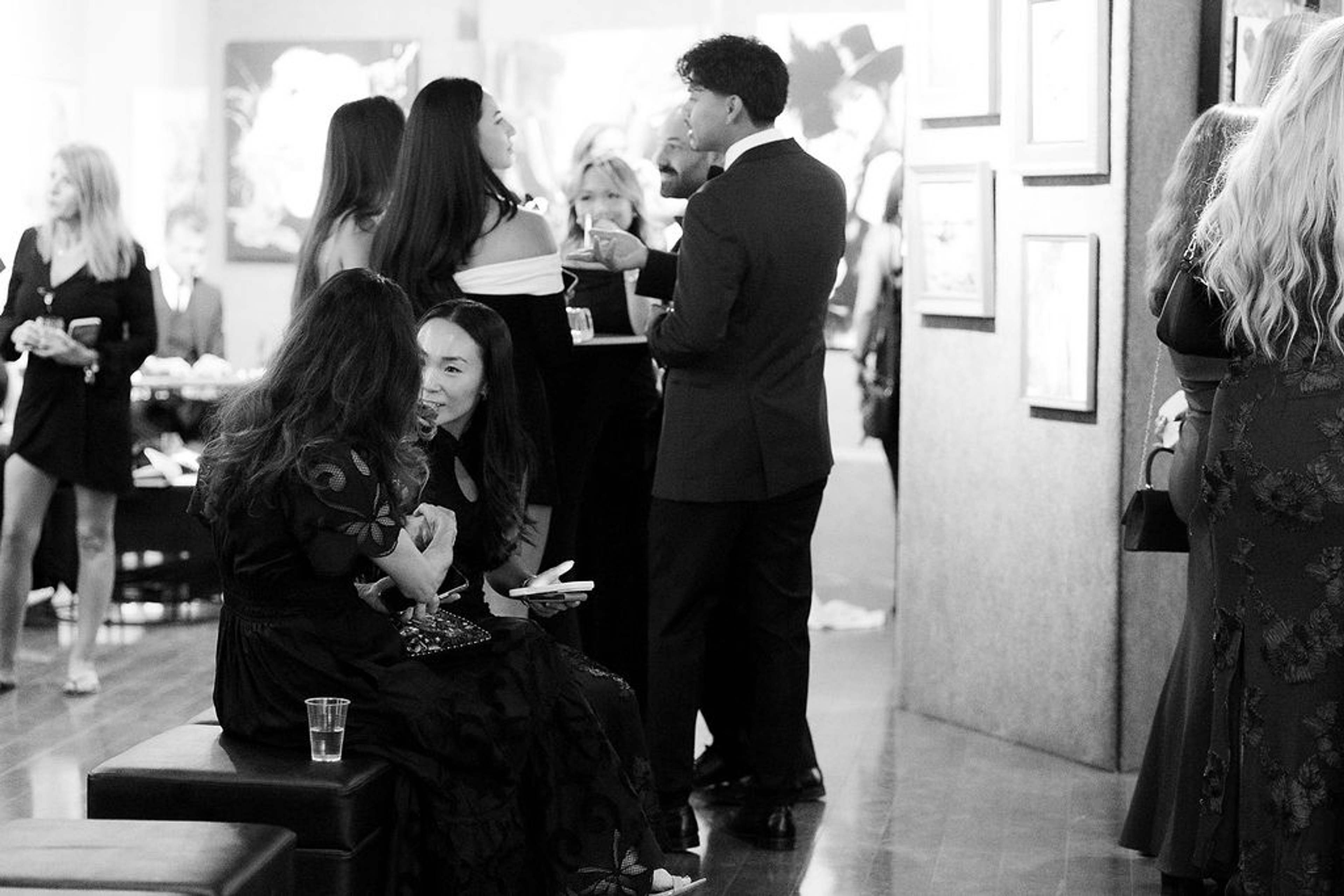 Guests seated and standing in conversation through the gallery