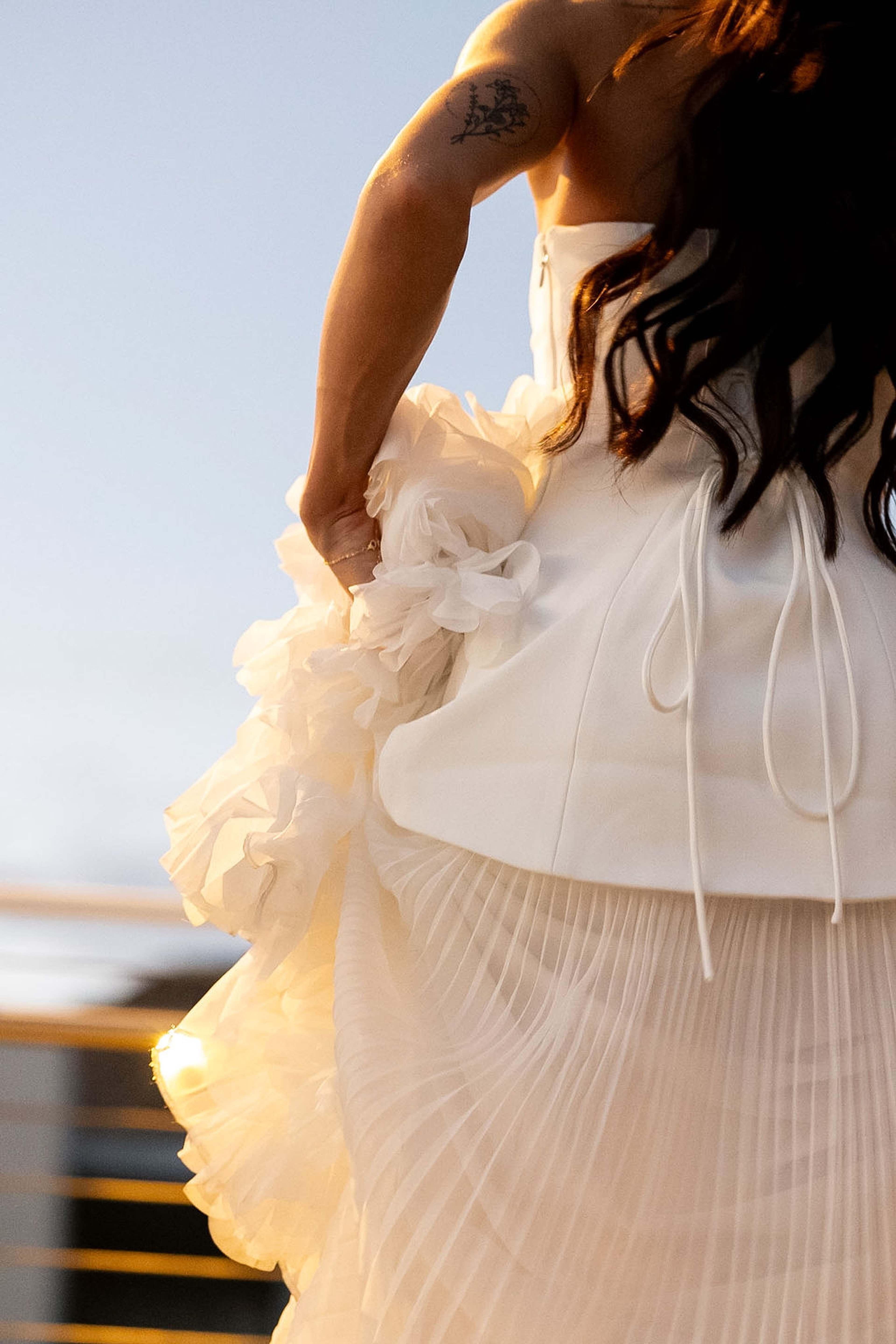 Close detail of pleated ivory fabric and a loose tie against warm low sunlight