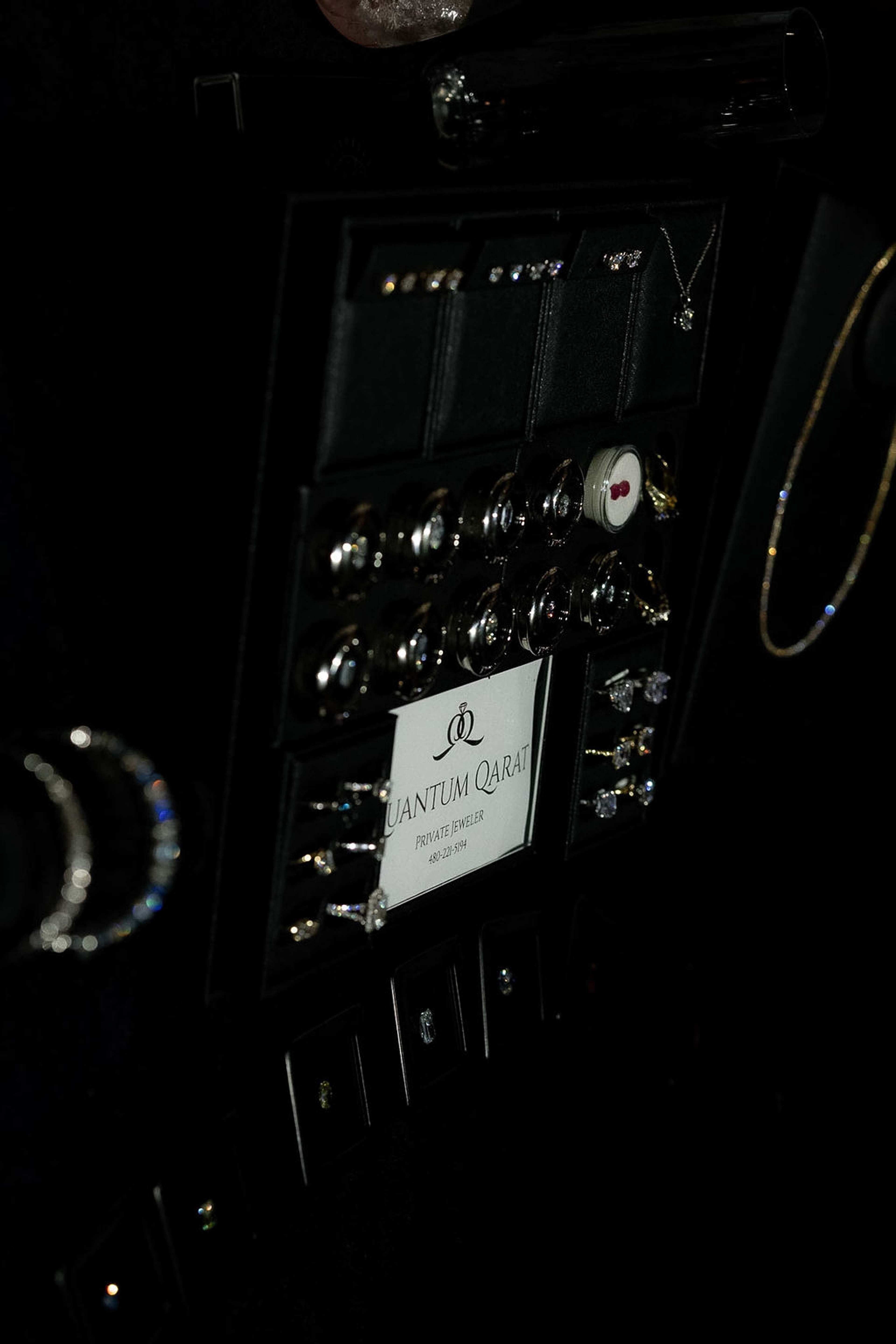 A dark jewellery case displaying earrings and necklaces behind a Quantum Quartz card