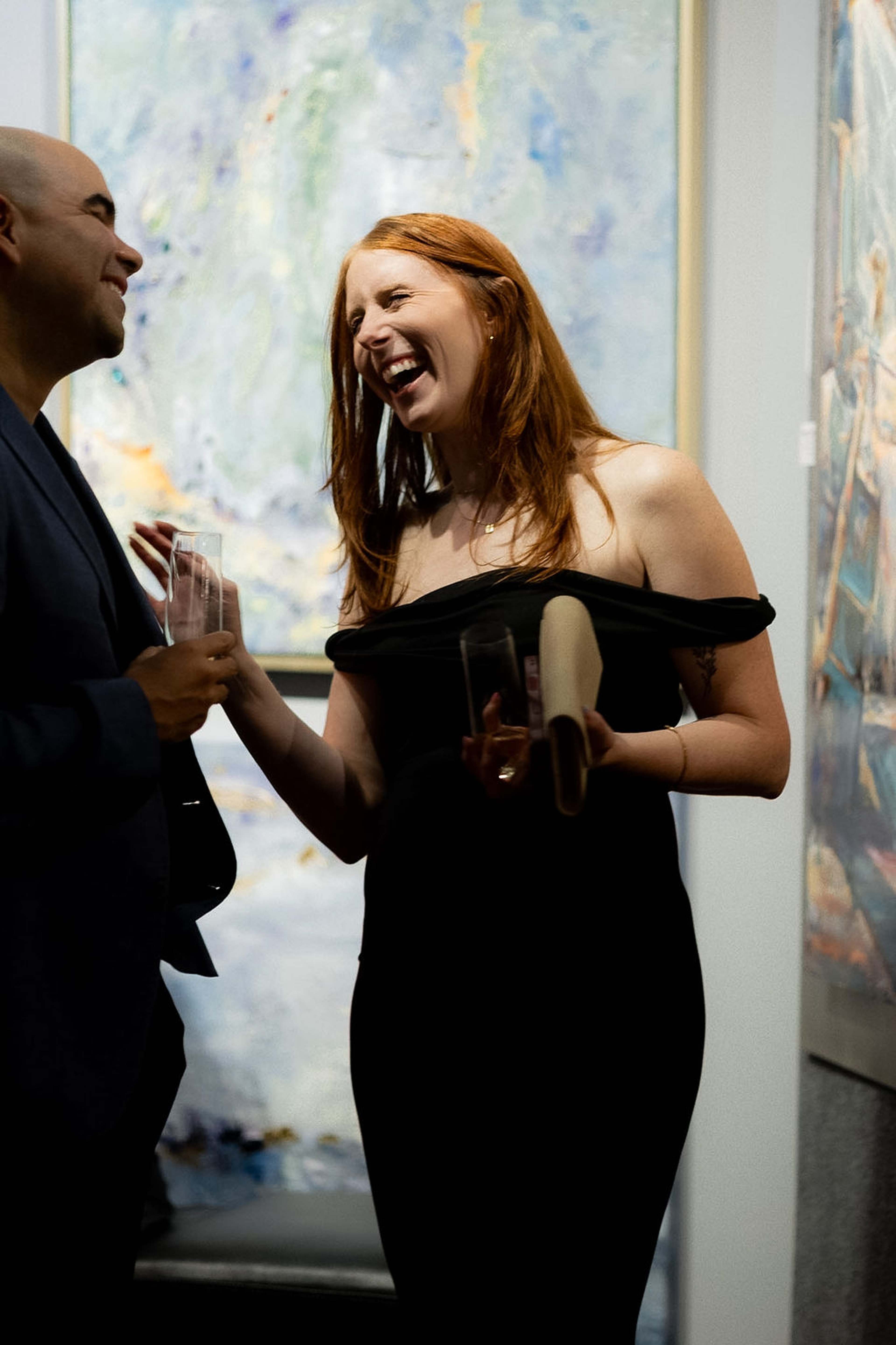 Guest laughing with a champagne flute during a conversation