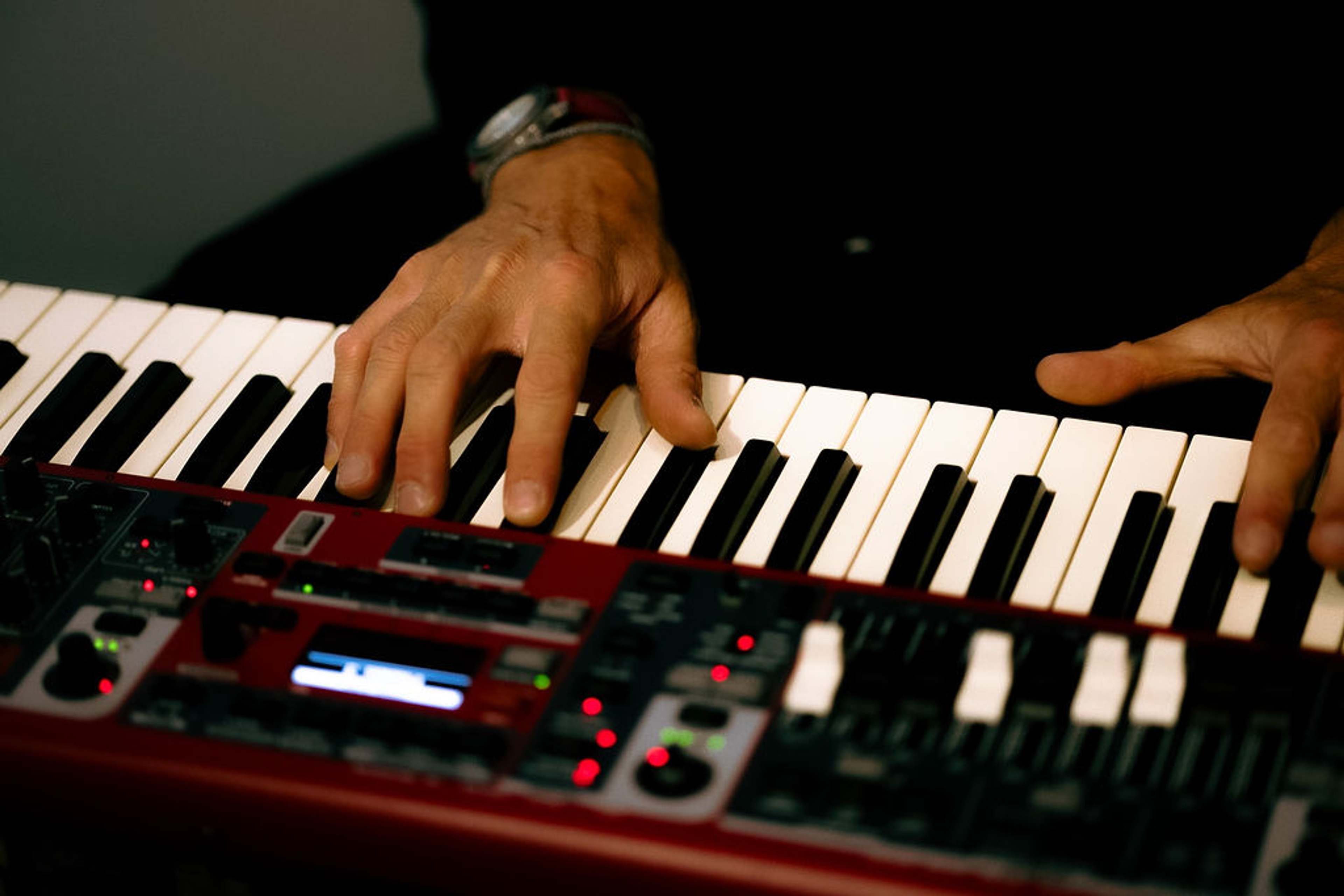 Close crop of the musician's hands on the keys