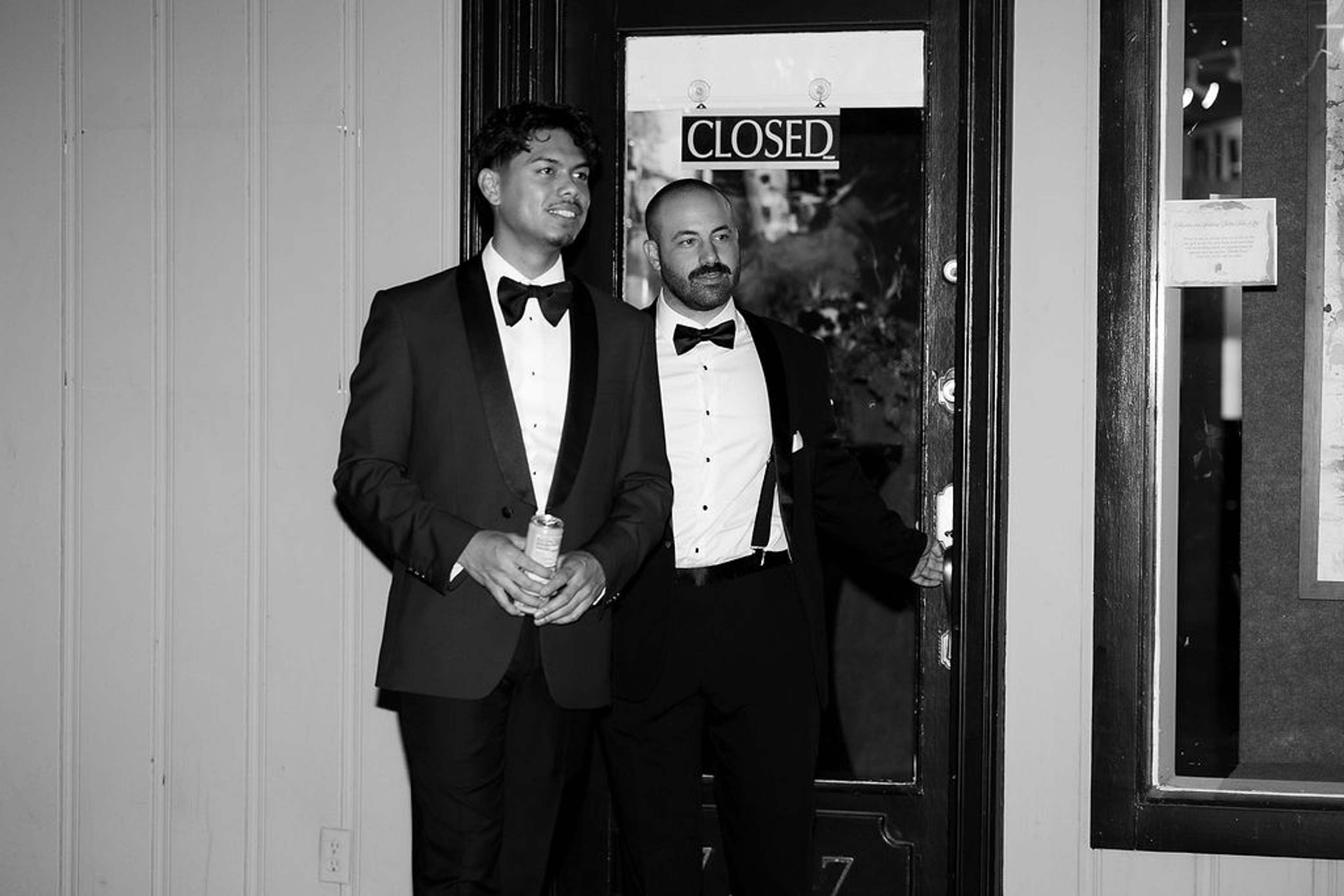 Two guests in black tie by the entrance door