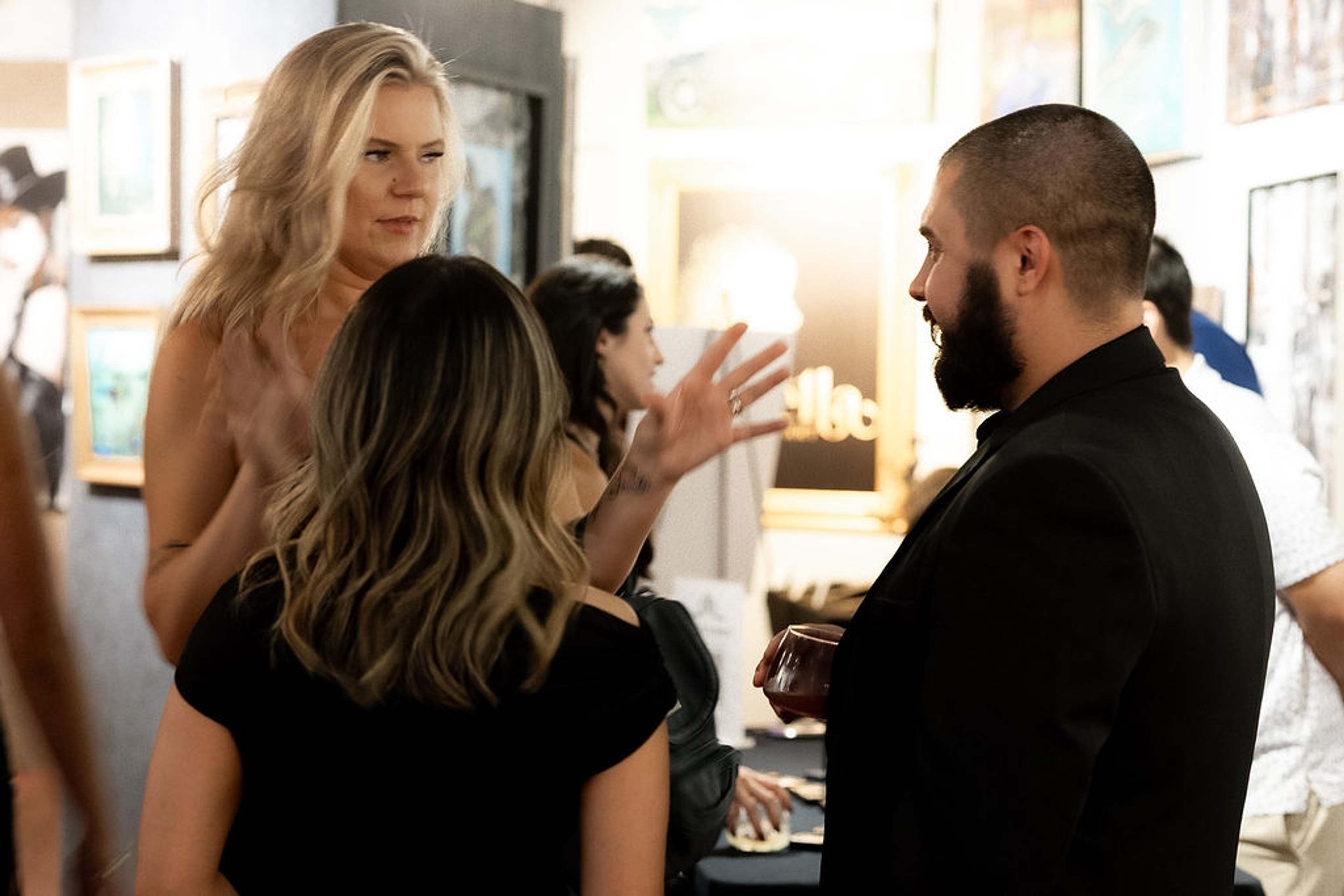 Guests in conversation, one gesturing as she speaks