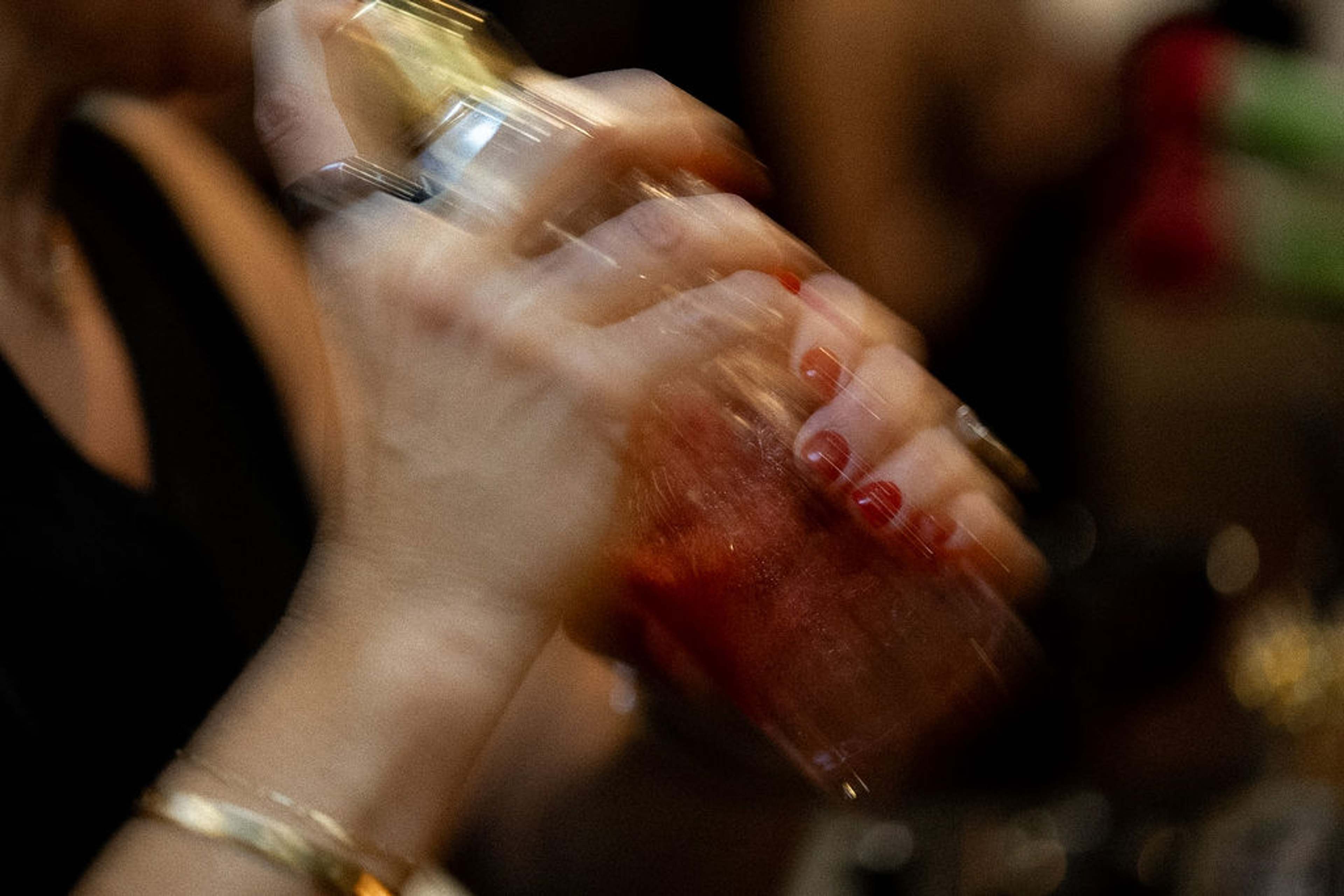 A cocktail being shaken behind the bar, caught in motion blur