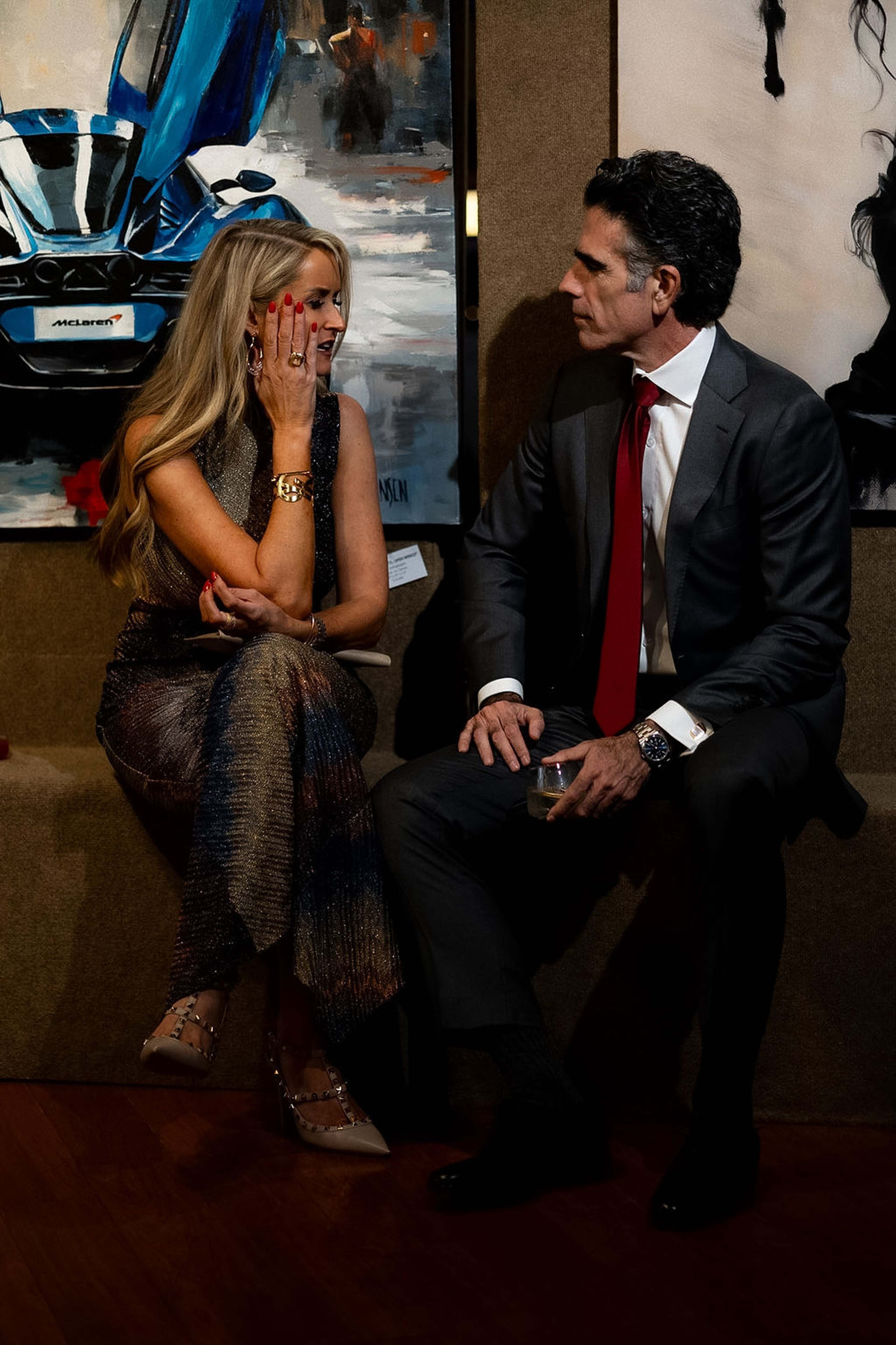 Two guests seated in conversation, one laughing