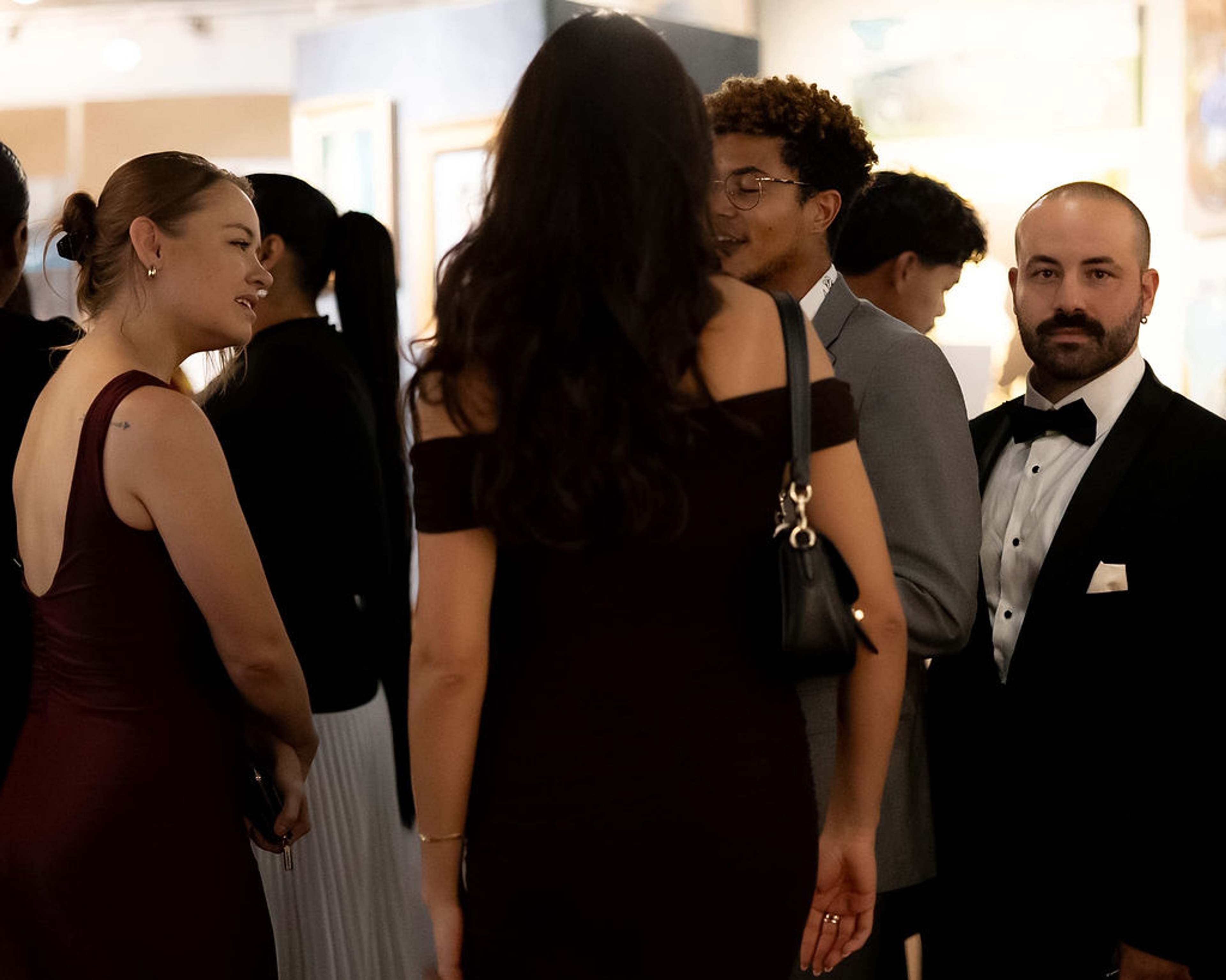 Guests in evening wear mingling in the gallery