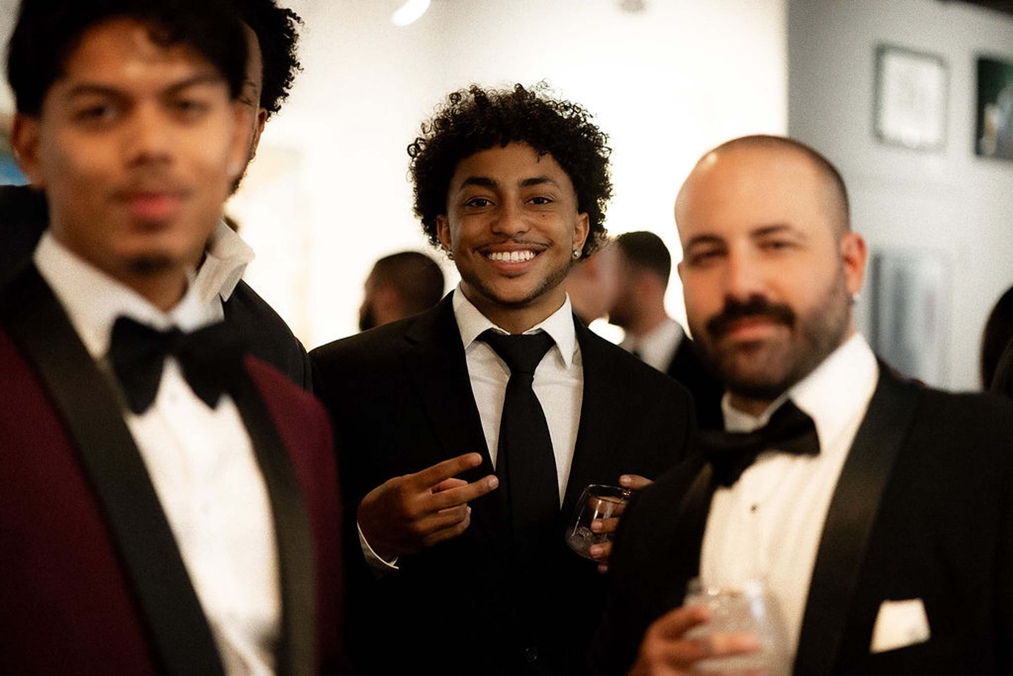Three guests in black tie smiling together