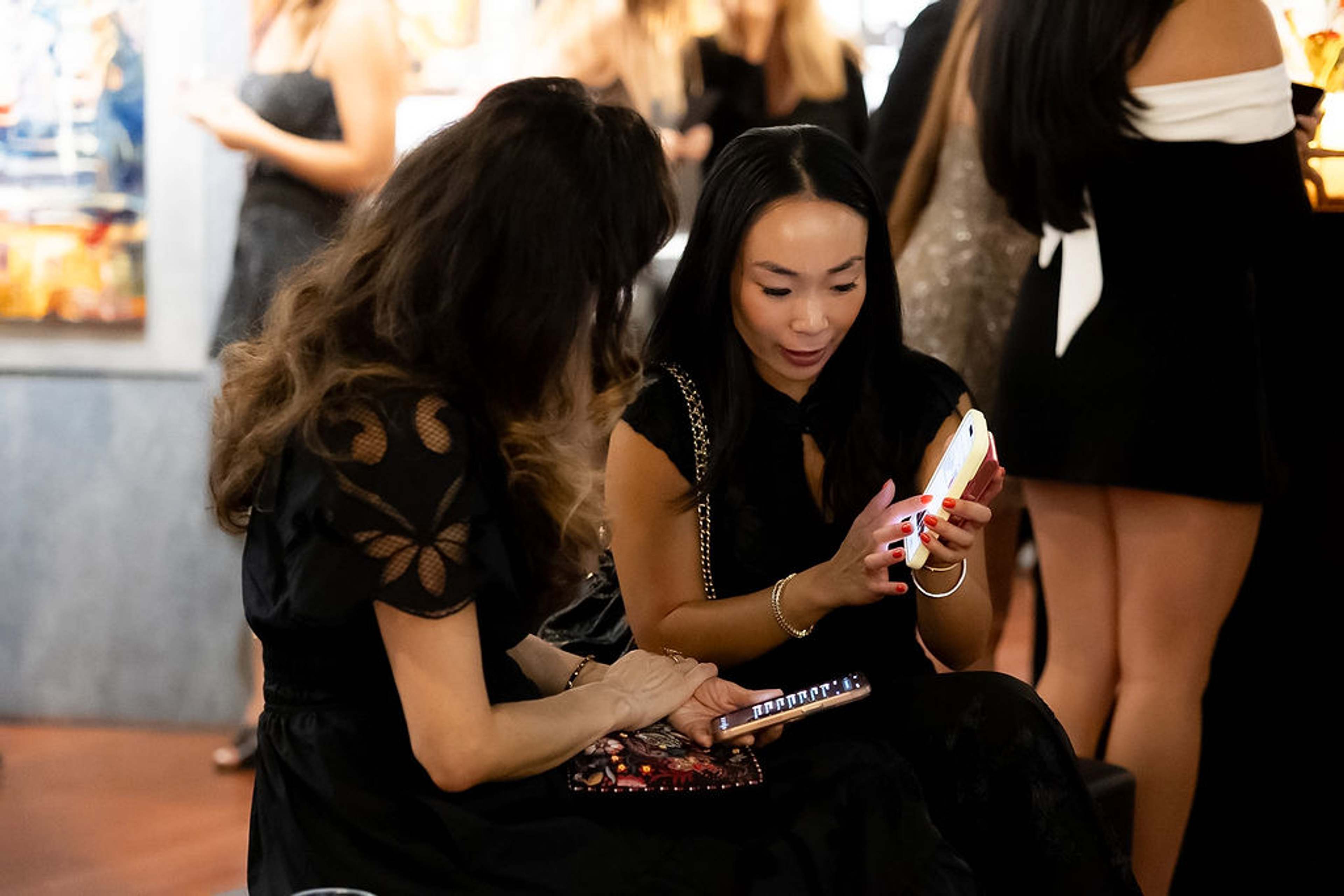 Two guests looking at a phone together