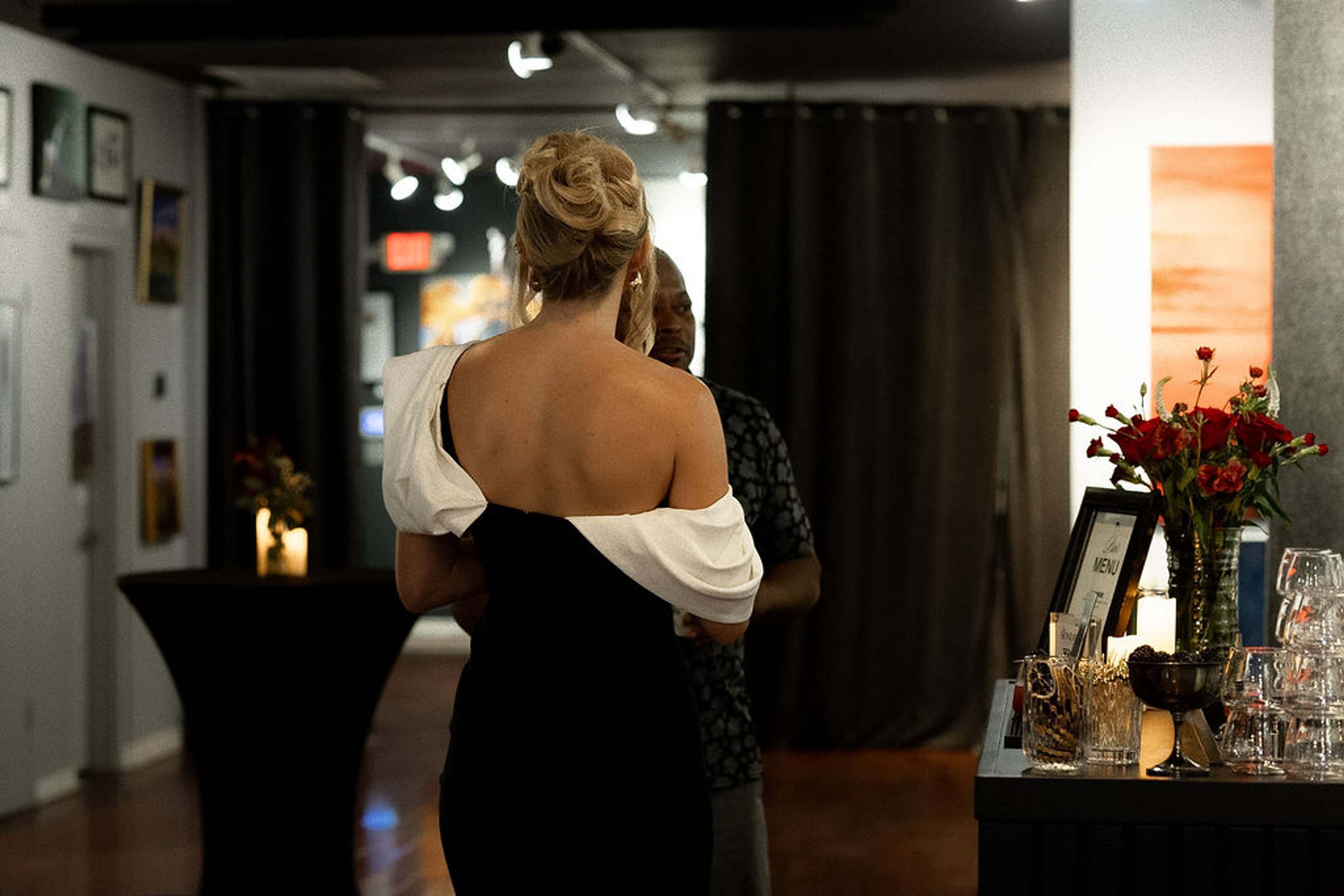 Guests watching from the back of the gallery, red roses on the table