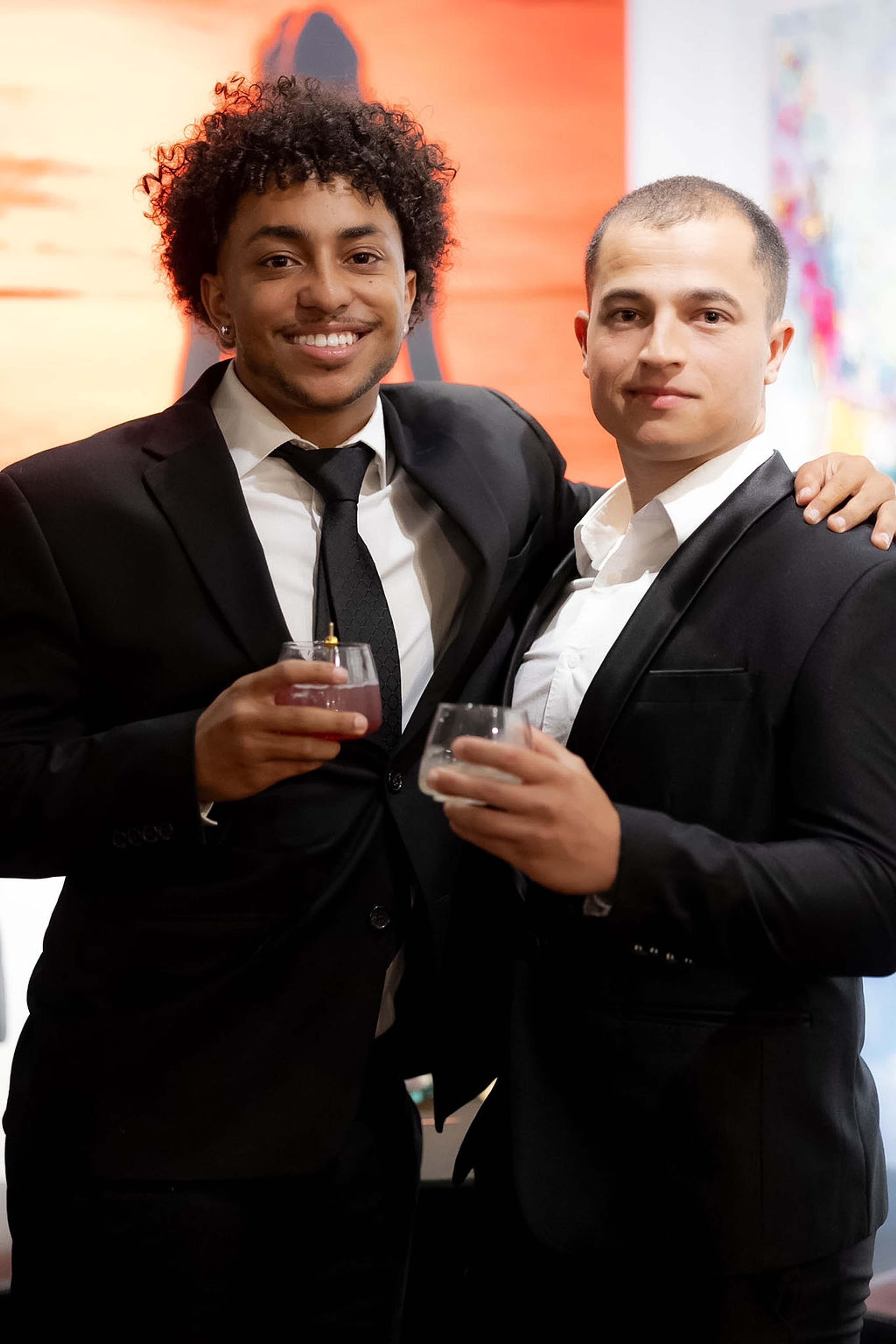 Two guests in black tie posed together with drinks