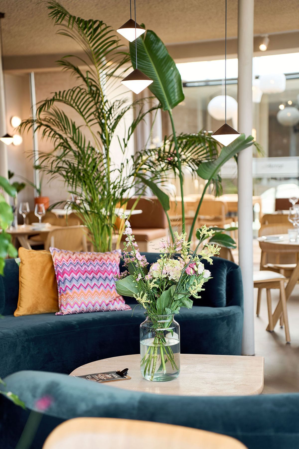 Zitgedeelte met planten in het restaurant van atMirror