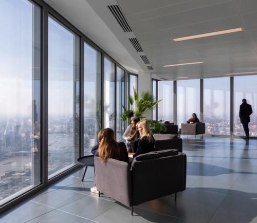 People sitting on sofas by floor to ceiling windows with panoramic views of London