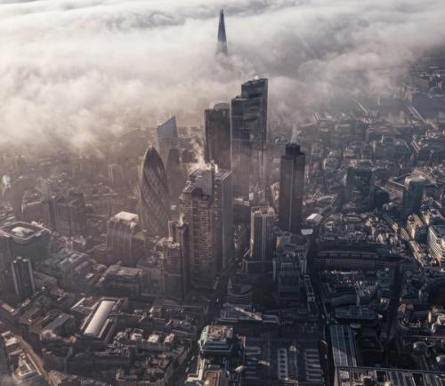Birds eye view of London with buildings breaking through clouds