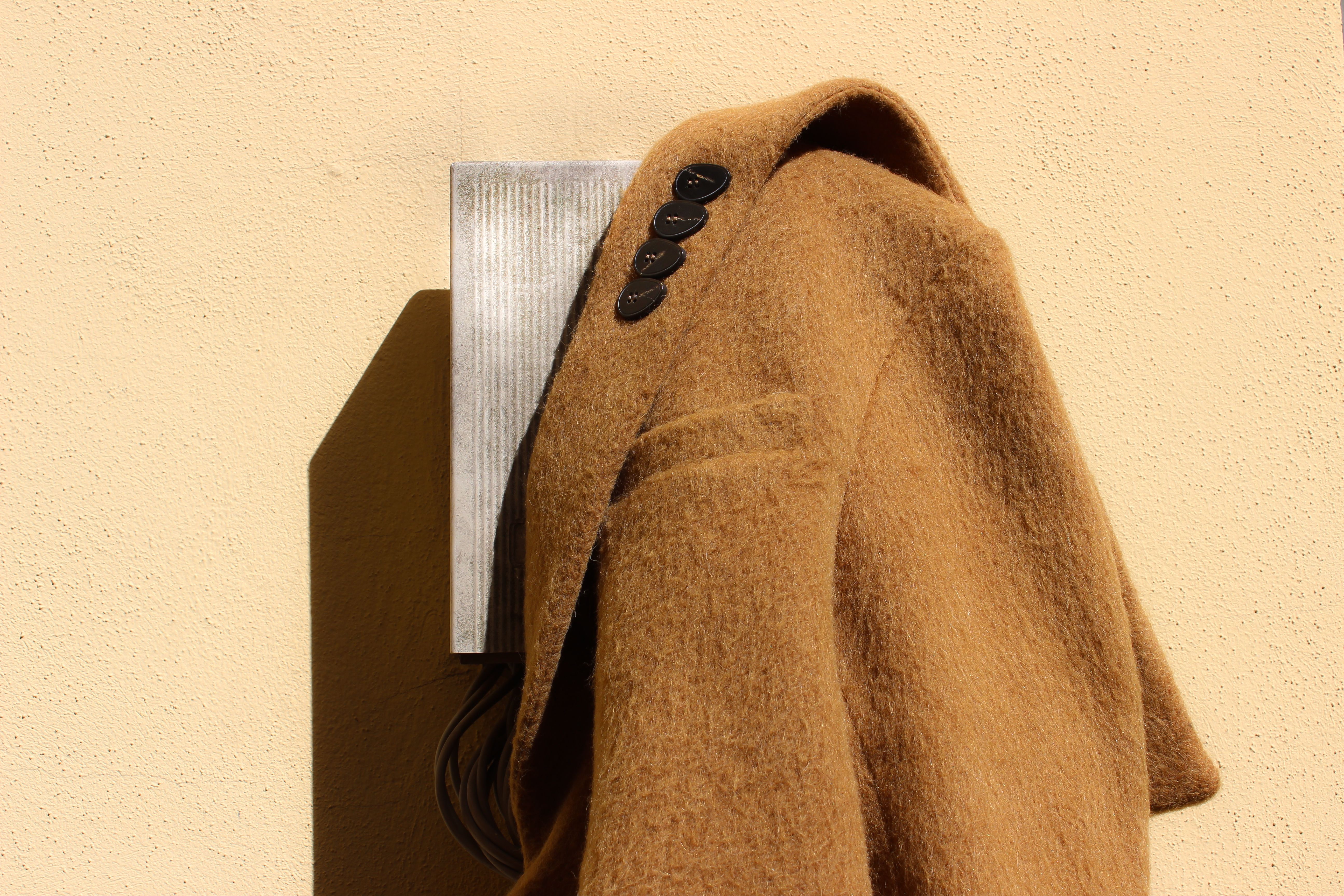 Close up of a coat hanging on an electricity box