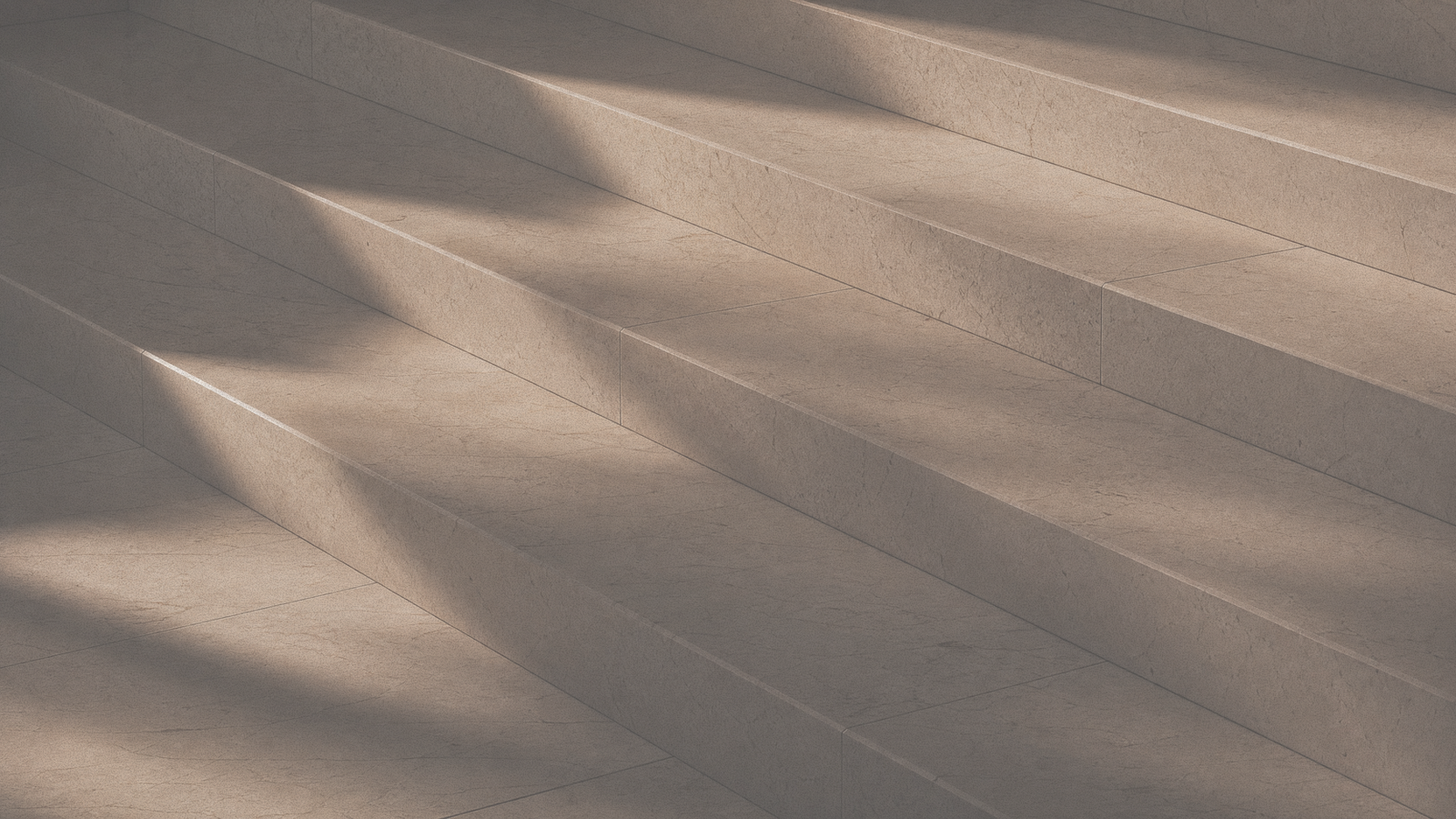 A staircase with strong diagonal light and shadow patterns.