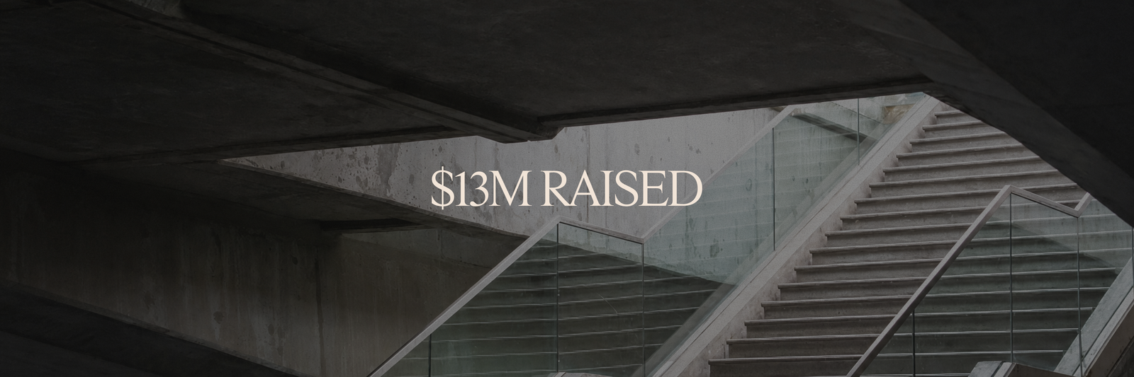 Modern concrete staircase with glass railings, overlaid with "$13M RAISED".
