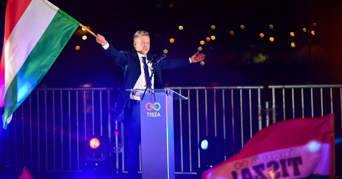Péter Magyar waving Hungarian flag behind a lectern at the election night party in Budapest