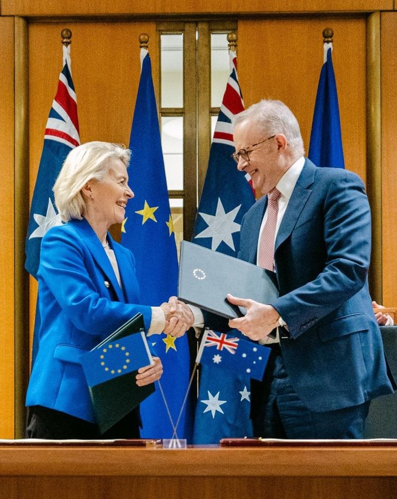 Ursula von der Leyen and Anthony Albanese shake hands and exchange documents