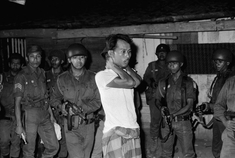 A man is taken away at gunpoint in Indonesia in November 1965
