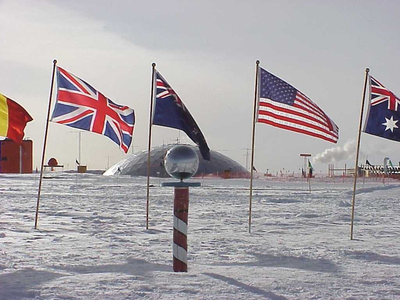 The ceremonial marker at the South Pole is surrounded by flags of the 12 original signatory nations of the Antarctic Treaty,signed on 1 December 1959 in Washington, DC. Image: Josh Landis/National Science Foundation.