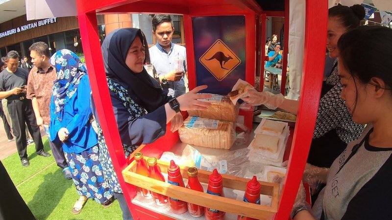Woman buying sausage sandwich