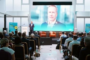 Conference stage at the M&A Summit on opening day 2025, with a large screen behind the stage and seating for participants in front of it