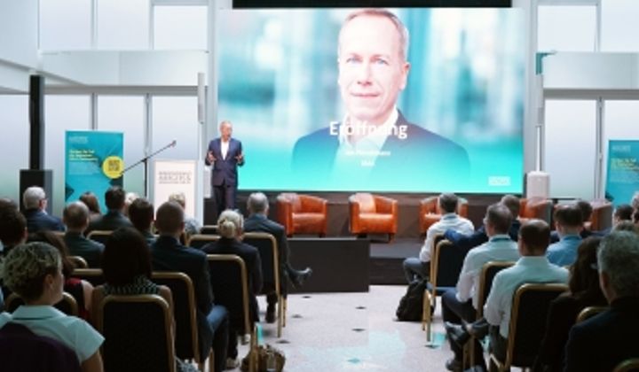 Conference stage at the M&A Summit on opening day 2025, with a large screen behind the stage and seating for participants in front of it