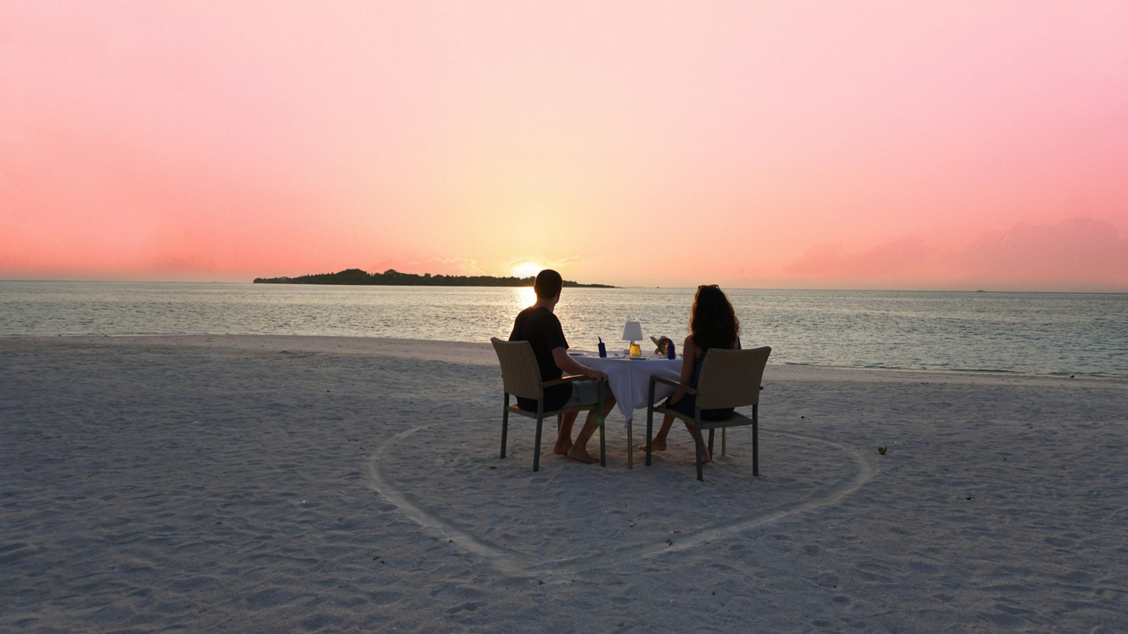 Couple on the beach watching the sunset