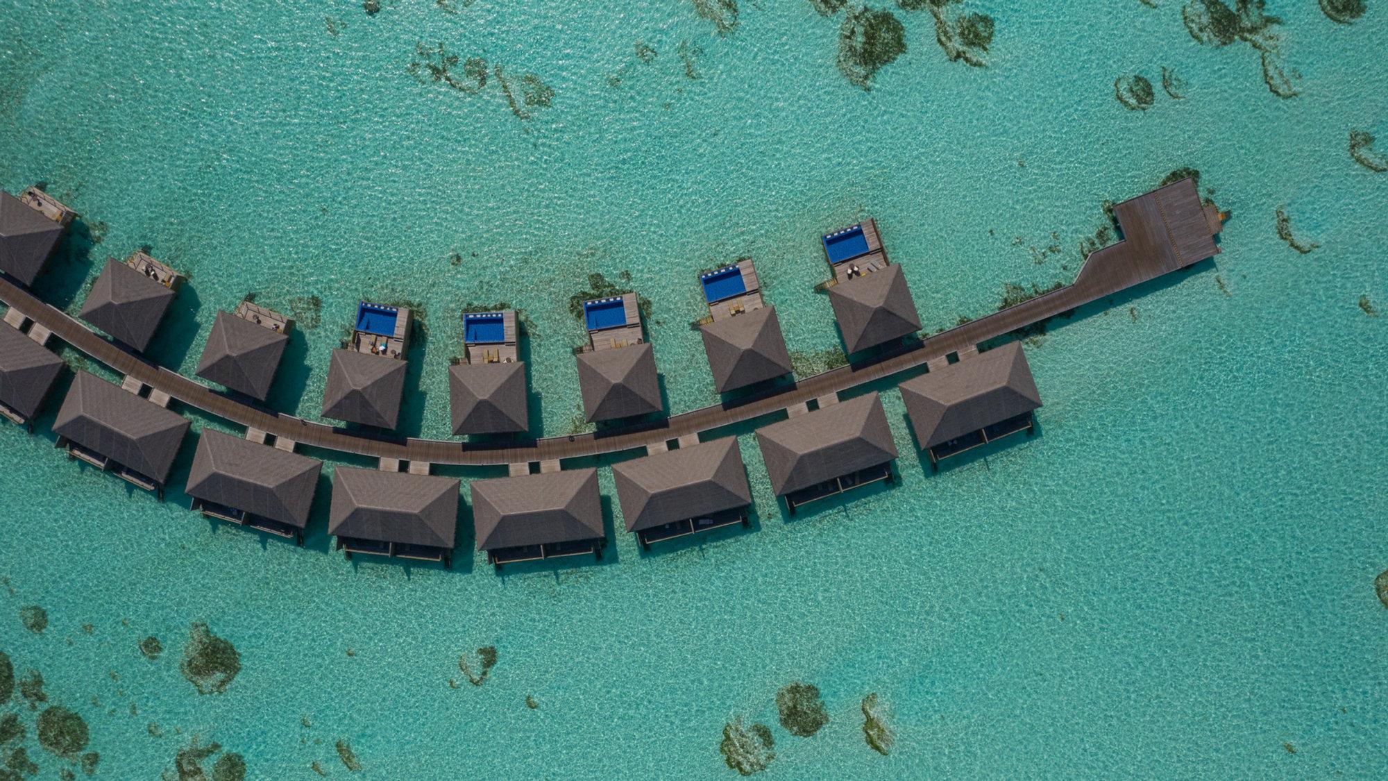 Aerial view of overwater villas above a turquoise lagoon