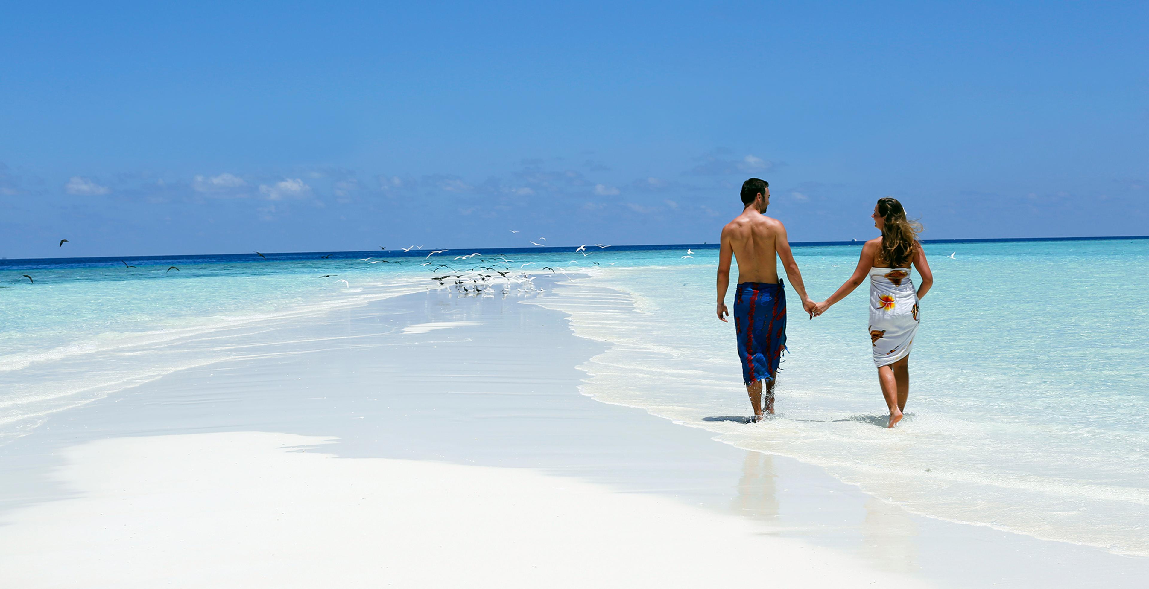 Couple walking on a sandbank near Nika Island