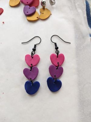 a pair of earrings with three stacked hearts, pink, purple and dark blue