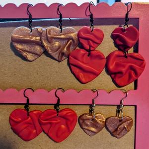 four pairs of satiny-looking heart shaped earrings made of polymer clay