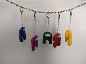 5 alien figures from the game Among Us, in different colors, hang from a necklace chain