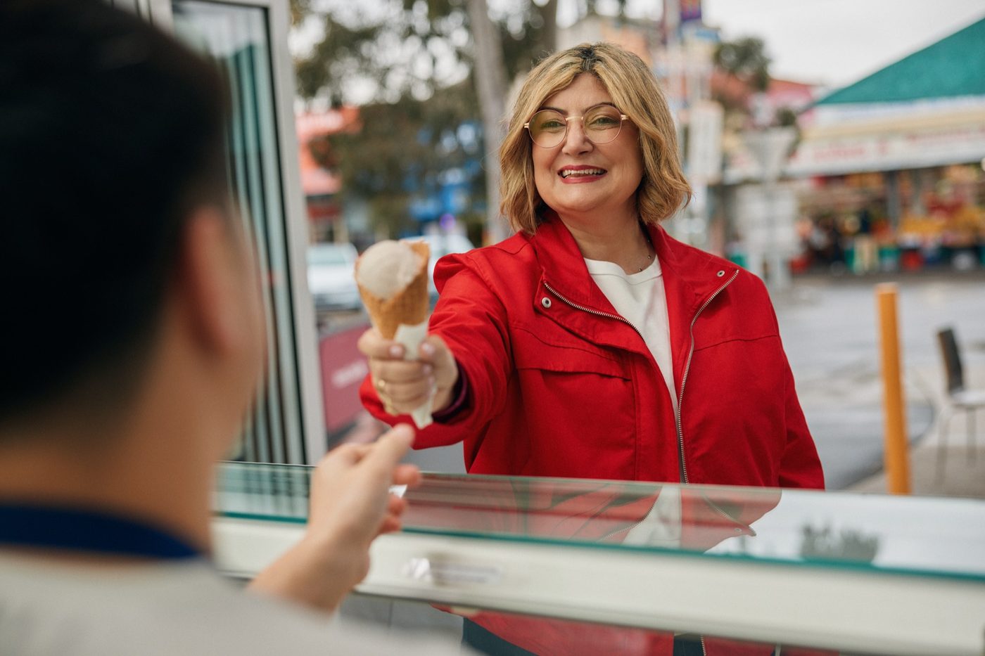 Natalie Suleyman handing an ice cream across the counter at a local shop